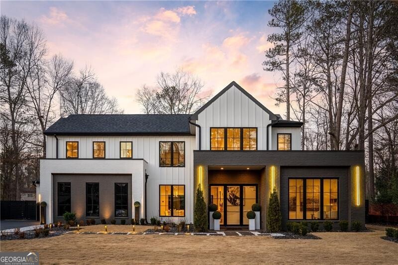 A triumph of modern design and craftsmanship, this distinguished modern residence in Alpharetta's coveted Garden District offers a seamless blend of luxury and resort-quality livability. Every element, from its striking architecture to its thoughtfully curated interiors, reflects an uncompromising commitment to quality and sophistication, all within moments of premier dining, shopping, and cultural destinations. A newly completed heated saltwater pool and raised spa, clad in black glass tile with a cascading waterfall, create a private resort-style retreat. A commanding fa ade, enhanced by precise landscaping and custom exterior lighting, introduces the home's luminous and flowing interiors. The two-story foyer, lined with wide-plank white oak flooring, leads to a series of spaces designed for both grand entertaining and intimate daily living. A private study with custom millwork offers a quiet retreat, while the formal dining room, anchored by a dramatic floor-to-ceiling glass wine display, sets an elegant stage for gatherings. At the center of the home, the chef's kitchen blends form and function with bespoke European-inspired cabinetry, waterfall quartz countertops, and a full suite of paneled Wolf and Sub-Zero appliances. An expansive island and adjacent butler's pantry, complete with a Miele coffee system, ensure effortless hosting. The adjoining great room, framed by an elegant fireplace with a custom surround, is bathed in natural light from a wall of sliding glass doors, seamlessly extending the living space to the fireside covered lanai. The primary suite, secluded on the main level, is a private sanctuary featuring vaulted ceilings, transom windows, and direct access to the lanai. Its spa-inspired bath is appointed with floating vanities, a soaking tub, an oversized glass shower, and a bespoke illuminated wardrobe system. Additional main-level amenities include a well-appointed mudroom, a designer laundry room with custom cabinetry, and a three-car garage with epoxy-finished flooring. Ascending the glass-railed staircase, the upper level reveals four generously scaled bedrooms, each offering distinct character. One, envisioned as a fashion atelier, boasts vaulted ceilings and clerestory windows, while another functions as an in-law or au pair suite, complete with a reading nook and a climate-controlled four-season lounge overlooking the estate-like grounds. Beyond the interiors, the outdoor spaces are designed for both relaxation and entertaining. The expansive terrace, finished with large-format tile, provides ample space for sunbathing, dining, and hosting against the backdrop of the stunning resort-style pool. Thoughtfully executed landscaping ensures privacy while enhancing the home's overall sense of tranquility. A rare offering in Downtown Alpharetta, this residence represents the pinnacle of contemporary luxury-where architectural precision, premier location, and an exceptional lifestyle converge in perfect harmony.