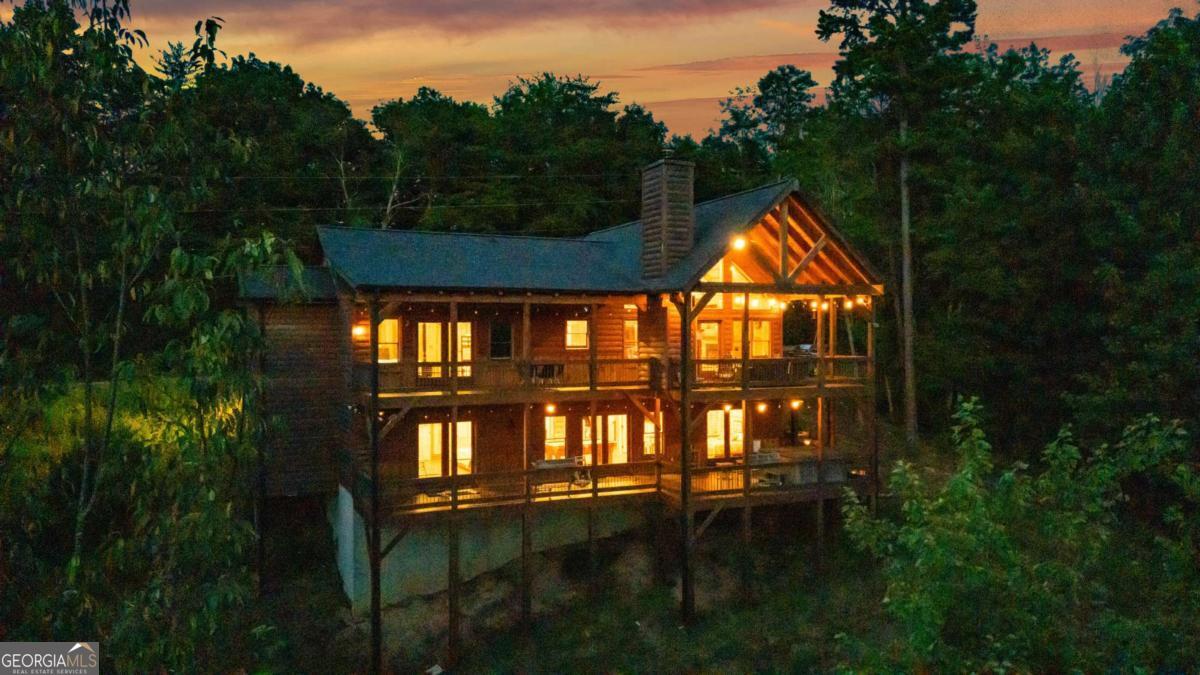 This is more than a cabin - it's a front-row seat to the Blue Ridge Mountains, with sweeping year-round views that stop you in your tracks the moment you arrive. Designed for both relaxation and unforgettable gatherings, this luxury log home delivers high-impact style with soaring cathedral ceilings, a dramatic wall of windows, and a brand-new deck made for mountain living. Watch the light shift across the ridges from your hot tub, share stories around the fire pit, or unwind with a book and the breeze - every corner is built to elevate your experience. The oversized primary suite offers generous space and a spa-style soaking tub perfect after a day of adventure. Downstairs, the game room and wet bar create a laid-back hangout zone for friends, family, or guests. A proven income-producing rental, this property includes modern touches like an EV charger and curated furnishings - fully turn-key and ready to go. And with tubing, hiking, fishing, and downtown Blue Ridge just minutes away, the location puts you right in the middle of everything that makes the Aska Adventure Area so sought-after. If you've been waiting for a mountain home that truly stands out - this is the one everyone will be talking about.