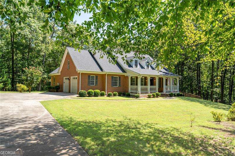 Spectacular Executive-style estate on almost 7 acres of gently rolling hills, mature hardwoods, and highly sought-after privacy. The residence, built in 2000, offers spacious living areas in addition to ample private sleeping quarters. True hardwood floors; traditional moldings and trim; plus over-sized windows bring warmth, character, and charm into this very special home. The generous-sized kitchen overlooks a sunny breakfast area with direct views to the heart of the home...the family room. The family room; with cozy, wood-burning, masonry fireplace and custom built-ins; opens to a lovely, light-drenched sunroom providing beautiful vistas of the rear yard and wooded landscape. Also located on the main level is the master suite...quietly tucked away from the rest of the living areas of the home...which includes an en suite bath (with both a separate shower and garden tub) and substantial walk-in closet. Two secondary bedrooms are located on the main floor with each providing direct access to a full bath. Upstairs, the living quarters include a bedroom room, full bath, and a very spacious flex space (perfect for a playroom, game room, media room, secondary den, or more). The HUGE unfinished attic area provides unlimited potential for additional expansion. The full-sized basement, with secondary, masonry fireplace and plumbing access, is as endless as the possibilities you can imagine for creating separate spaces for each member of the family! The location is UNPARALLELED in its seclusion, privacy, and tranquility, and all within approximately 4 miles to GA400/19 at Hwy 53...an area known for some of North Georgia's best shopping, dining, and more! An opportunity, such as this, providing the best of both worlds is a rarity! Don't miss out. Check out the photos and schedule your appointment to see it in person. Listing Agent is related to Seller.