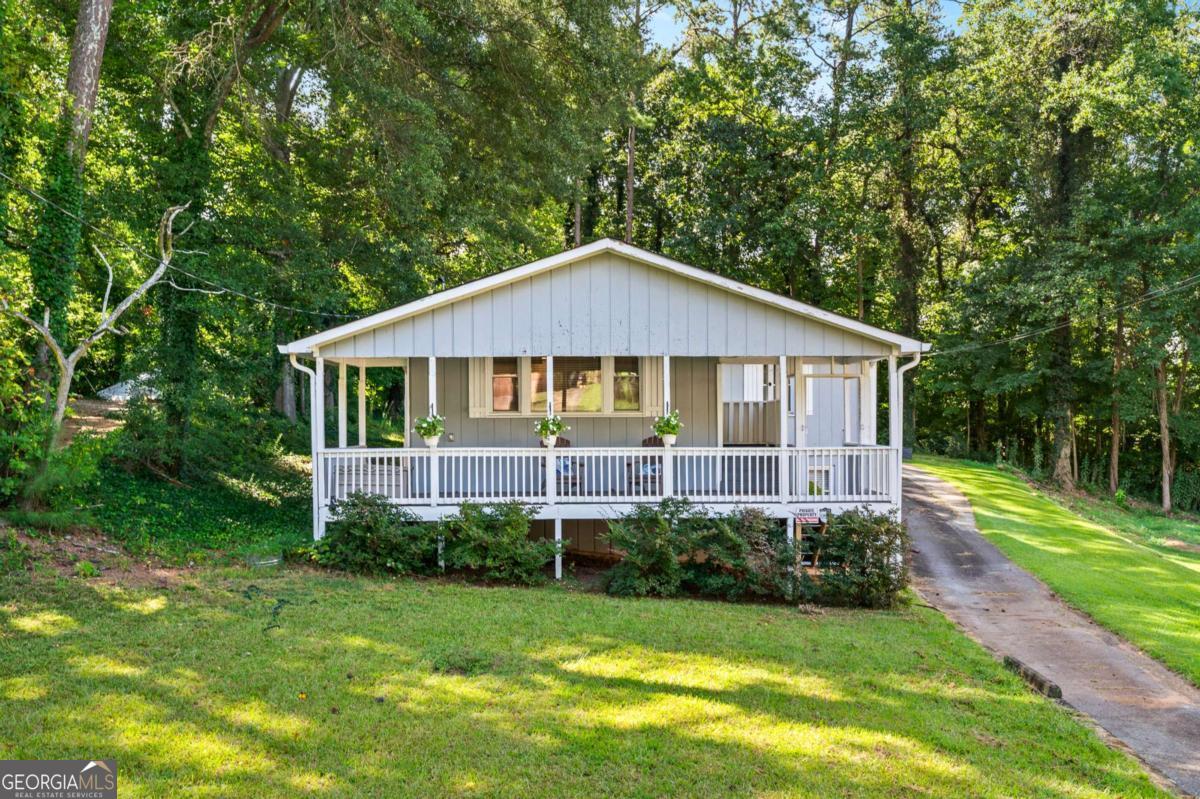 Welcome to this beautifully updated home situated on a spacious lot with a wooded backyard-offering complete privacy and no future building behind you. Enjoy peaceful mornings on your private front porch, perfect for a cup of coffee or quiet relaxation. Inside, the open-concept layout is bright and inviting and the layout is ideal for entertaining, with plenty of space for both a large dining area and oversized living room furniture. The updated kitchen is a true showstopper, featuring stainless steel appliances, ample counter space, and modern finishes. Both bathrooms have been tastefully updated, and the oversized primary suite boasts separate his-and-her closets. Two spacious guest bedrooms provide comfort for family or visitors, while the laundry room is conveniently located in the mudroom as you enter from the back. A single-car garage with an additional carport offers plenty of parking and storage. Downstairs, you'll find a versatile space perfect for a workout room, home office, or bonus room-tailored to fit your lifestyle. With no HOA, this home gives you the freedom you want in a beautiful, private setting.