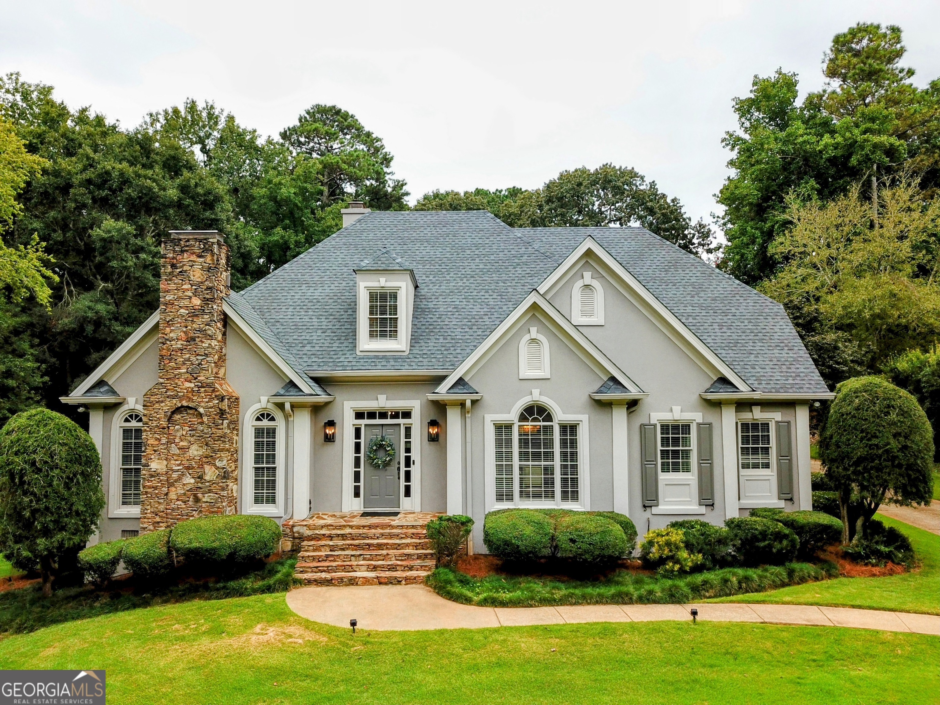 Welcome to 118 Moss Creek Drive, a beautifully renovated 5-bedroom, 3 full bath, 2 half bath home in the sought-after Lake-Pool-Tennis community of Moss Creek. Move-in ready and thoughtfully updated inside and out, this spacious property combines timeless craftsmanship with modern conveniences. The main floor showcases brand-new 8" Charleston Collection French Oak hardwoods (2025), offering warmth and sophistication throughout. The fully renovated kitchen features shaker-style cabinet fronts, Montauk Hanstone Quartz countertops, a Chatham Tybee White ceramic tile backsplash, updated sink and faucet, hardware, and designer light fixtures. Just off the kitchen, the mudroom was refreshed with quartz countertops, sink, faucet, and shaker cabinetry. A stylish powder bath remodel (2025) adds new lighting, mirror, wallpaper, solid wood vanity, and Carrara marble countertop. The home's thoughtful layout includes a spacious main-level bedroom with a full bath, perfect for guests or multi-generational living. The lower level also offers a dry bar and flexible living space. Upstairs, new carpet (2022) enhances comfort in the private bedroom retreats. Notable improvements include: Exterior & Systems: New architectural shingle roof (2024), exterior painted (2024), attic insulated and floored (2024), new gutters (2022), 80-gallon Bradford electric water heater (2020), Trane HVAC system (2018), and septic serviced (2021). Kitchen & Appliances: Bosch dishwasher (2023), GE range (2022). Bathrooms: Fully tiled downstairs bath added in 2022; stylish powder room remodel in 2025. Lower Level: New Aquaguard waterproofing (2023); mini kitchen with granite countertops, backsplash, and cabinetry (2021). Additional Upgrades: Locker room and laundry cabinetry (2022), new LVT flooring downstairs (2021). The property also offers a spacious 3-car garage with an extended bay-ideal for boat storage, workshop, or extra vehicle space. Relax on the covered porch or enjoy Moss Creek's amenities, including a pool, tennis facilities, and a community dock on West Point Lake. This meticulously cared-for home, originally built in 1990, has been consistently updated with quality materials and design. From heirloom-quality hardwoods to modern kitchens and baths, every detail has been considered. Truly move-in ready, 118 Moss Creek Drive is ready to welcome its next owners.