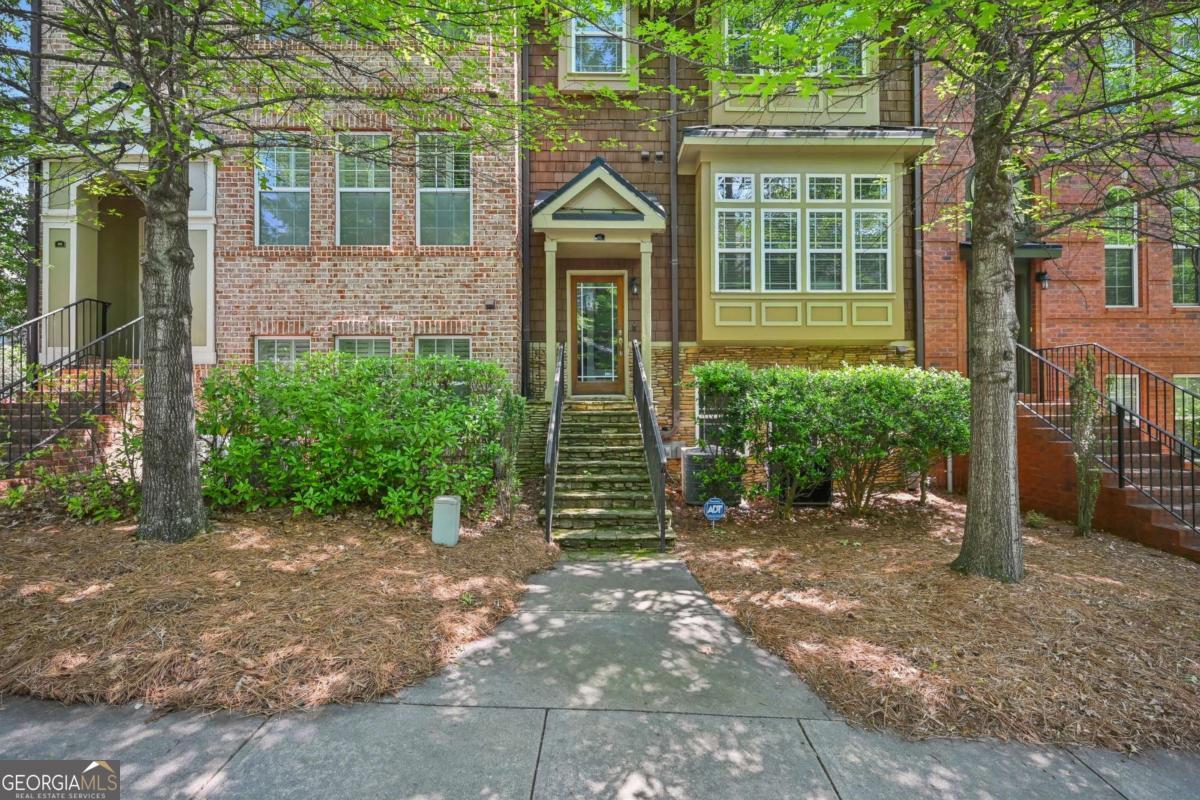 Stunning renovated 3-bedroom, 3.5-bathroom townhome in the heart of Sandy Springs, offering the feel of new construction with thoughtful, high-end finishes throughout. Located in Johnson Creek, an intimate community of just 33 homes, this property is minutes from downtown Sandy Springs, City Springs, top restaurants, shops, parks, and the Performing Arts Center. The chef's kitchen features custom cabinetry with pullouts and dividers, a large island with farmhouse sink, built-in dishwasher, trash compartment, stainless steel appliances, and a walk-in pantry with sliding barn door. The living room includes custom built-ins, wine rack and fridge, floating alder wood shelves, and a fully redesigned fireplace with marble herringbone surround, shiplap, and alder wood mantle. Main level features gleaming hardwoods and an updated powder room. Upstairs, the oversized primary suite boasts a luxurious renovated bath with white oak cabinetry, vanity station, herringbone tile, a large walk-in shower with waterfall rainhead, dual handheld sprayers, and a large niche-plus a massive custom walk-in closet. A renovated en suite secondary bedroom and expanded linen storage complete the upper level. The terrace level offers a third bedroom or flex space with full bath and direct access to a two-car garage and private parking pad. Enjoy the expansive back deck-your own private outdoor retreat-ideal for entertaining and relaxing. A rare opportunity in one of Sandy Springs' most desirable communities.