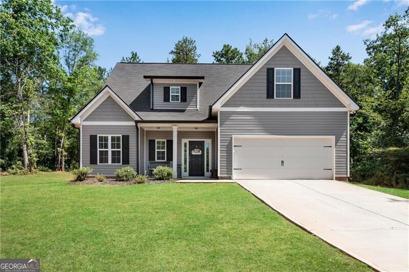 SGW Homes "Oakdale" Plan featuring Primary Suite on Main built on just over an acre private wooded lot! Enjoy quiet peaceful living off this county maintained gravel road. Easy to maintain vinyl exterior. Front porch opens to the foyer w/luxury vinyl flooring extending through all main living areas and baths. Granite Island eat-in kitchen w/walk-in pantry views the great room w/wood burning fireplace. 2" blinds throughout. ALL ELECTRIC HOME - NO HIGH GAS BILLS! Primary suite features a HUGE walk-in closet, double vanity, garden tub and separate shower. ALL bathrooms feature granite counter tops. Upstairs offers a loft area 3 secondary bedrooms and 2 full baths. Just 15 minutes to Tanger Outlet Mall and Dining. NO SUBDIVISION - NO HOA - INVESTOR FRIENDLY!