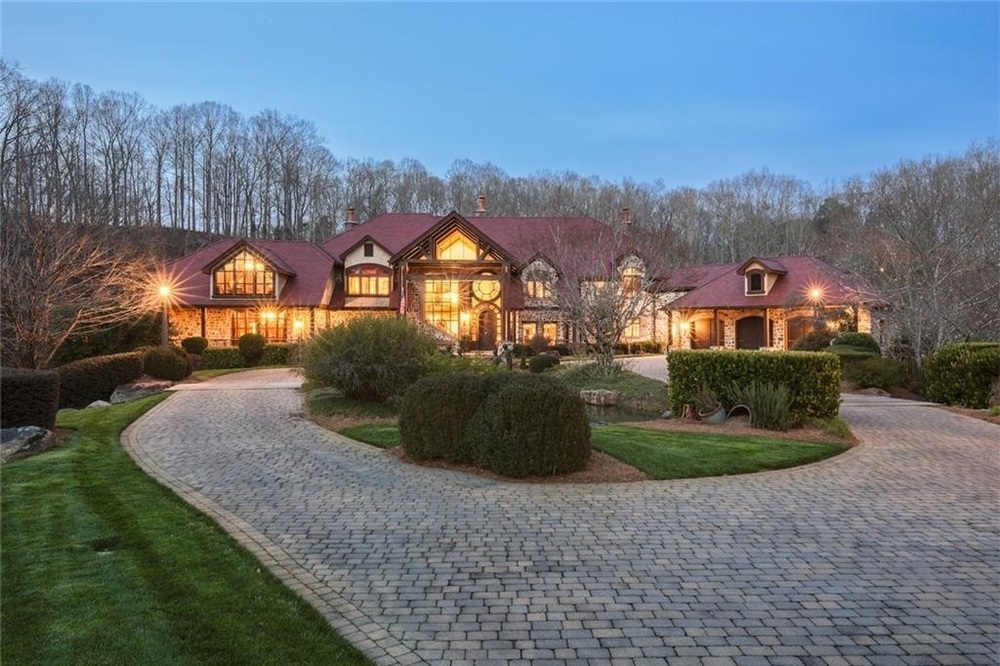 Spectacular property and residence that is maintained to perfection. Within an hour from Buckhead you arrive to 446 acres of rolling, fenced pastures, a winding river with waterfalls and lake all surrounding the main residence built of stone and a very rare red slate roof. The attention to detail in the materials used to build the house are evident from the doors to the reclaimed beams, wide plank floors and interior finishes. Massive patios wrap around the house, approximately 6000 square feet to enjoy the views of river/waterfalls. Wind down the drive to the luxury car facility that will hold up to 75 cars that has authentic gas station and saloon bar that overlooks the cars. Perfect for the car collector and entertainers drive with privacy, rolling pastures, a five acre lake and completely fenced with a front and back gate.  So rare to have this much property and exactly an hour north of Buckhead or a 15 minute helicopter ride. Or consider this property for a very private corporate headquarters. The possibilities are endless!