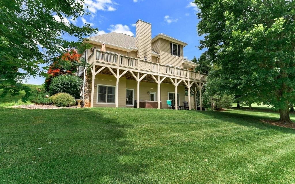 SPACIOUS 4 BEDROOM HOME IN GATED UPSCALE GOLF COURSE COMMUNITY! Overlooking the 1st fairway, this quality built, beautifully landscaped, 4 bedroom/3.5 bathroom home offers a great room w/ stacked stone wall & gas log fireplace, cathedral ceiling, wood floors, kitchen w/ granite counters & stainless appliances, breakfast nook & dining room, office, gym, living room, open air & covered deck, concrete patio w/ hot tub, master with trey ceiling on main, 2nd master & kitchenette on lower level, master bathroom w/ x-large glass & tiled shower & 2 bonus rooms. Although private by landscaping the home is 1 lot away from the spectacular clubhouse with restaurant, fitness center and pool area. COMFORTABLE, LUXURY LIVING IN THE NC MOUNTAINS!