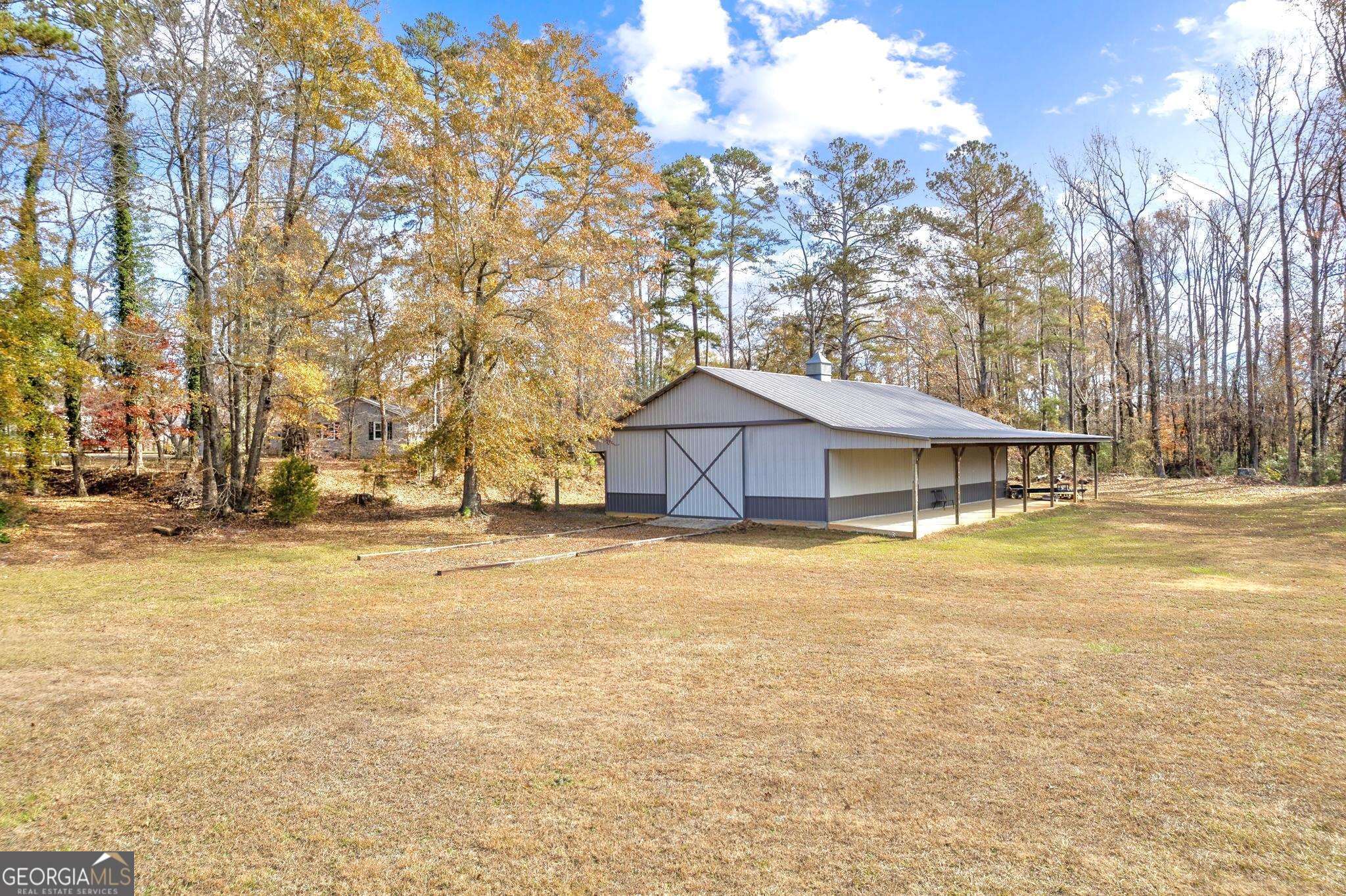 STAKE YOUR CLAIM IN NORTH FORSYTH COUNTY. Embrace the tranquility of the countryside on this sprawling 10.93 acre property nestled along Dr. Bramblett Rd in highly sought-after North Forsyth County. Zoned agricultural, this lush fertile farmland is bordered by Settingdown Creek and contains a beautiful mix of brush, pasture, forest and captivating wildlife. This private oasis includes a 4 bed/ 2 full bath stone frame ranch home, as well as a newly built 2400 square-foot pole barn. Located steps from the main house, this captivating barn is equipped with 3 double entry/ exit industrial sliding barn doors and 1 pass-through door. The possibilities are endless with this overly spacious standalone addition. This serene property truly encompasses "living on the land", but with all the advantages of the convenient proximity to main attractions, schools & major roadways. It truly IS the best of both worlds. No HOA, No city tax. Located 5.9 miles from Cumming City Center -- 9.5 miles from GA-400 -- 10 miles from North GA Premium Outlets.