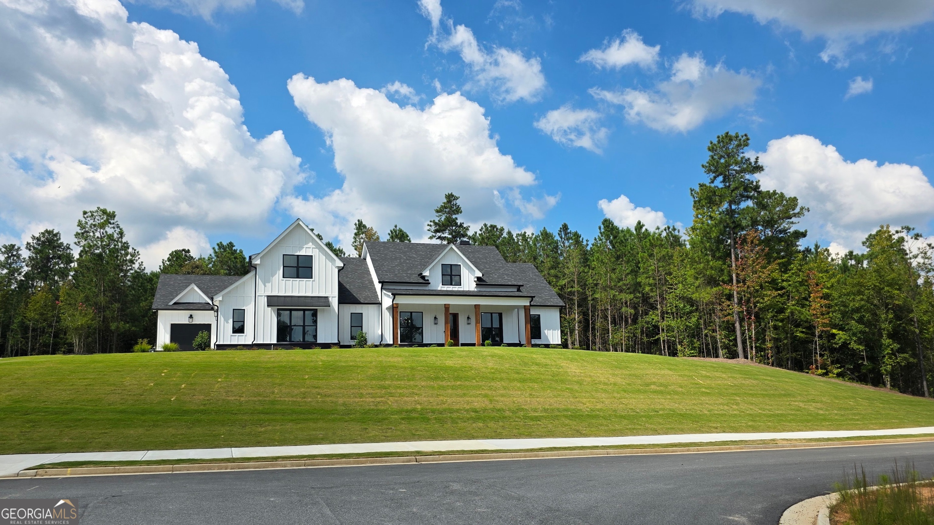The quality & features really come alive in this Gorgeous Modern Farmhouse plan built by Southern River Homes. Ready for its new owner and finished in high end features throughout the home. Are you crazy over kitchens? This one has it all: Large island with extra storage and pendants; Huge walk in pantry with "costco" door from garage; Wet bar/Butler's pantry entry to the dining room with ice maker & glass upper cabinets; Wide open views of the great room & rear-outdoor entertainment; plus Over the Top GE Cafe flat black appliances with large cook-top-Double smart ovens-2 dishwasher drawers & microwave drawer! Hardwood flooring covers all living areas on both levels and includes the wood tread stairs. The dining room off of the 2 story foyer is both elegant and warm and inviting with stained beam ceiling. Maybe the Master suite is your love: Spacious bedroom with tray ceiling; Double door access to roomy bath suite that includes double vanity-linen cabinet-black stone composite tub; access to a "Store it All" walk in closet that opens to the Laundry room with cabinets galore. The great room is open, bright and boasts a floor to ceiling white stone fireplace that will have everyone talking. Three additional secondary bedrooms on the main level: Front two share a double vanity bath with accent tile in the tub/shower & the rear bedroom has a private suite with full bath attached boasting a large walk in shower. Upstairs is the oversized bedroom 5 with walk in closet & private bath. It would also make a great bonus/play room for adults and/or kids. If the garage is your thing, check out the 3 car design with epoxy flooring. Love the great outdoors? What about a slate covered-cedar post rocking chair front porch with views from the most elevated lot in this phase, you can look over the neighborhood and enjoy gorgeous views whether sipping coffee or wine. You will also love the huge level rear yard that would be perfect to play in or add a nice pool to in the future. Don't forget the paver covered rear porch with brick fireplace that overlooks the fun.