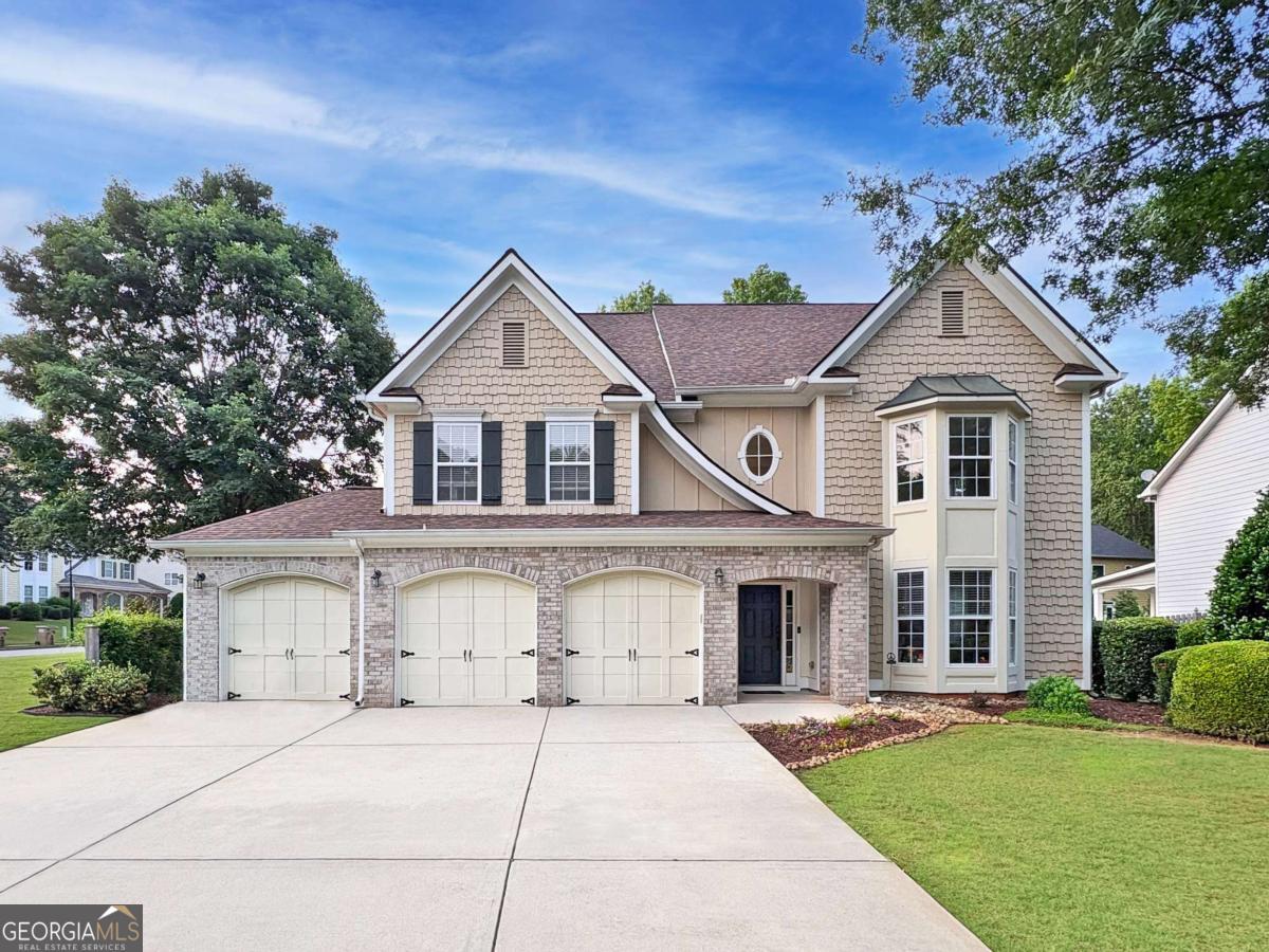 WELCOME HOME to this impressive three-level 7 bedroom, 4 bathroom, 3-car garage craftsman/traditional home perched on a corner lot in the desirable Lambert High School district community of Caney Creek in Cumming! This fabulous home features an open floor plan with a spacious two-story entry and living room, on-trend wide plank hardwood floors, and a convenient main floor guest bedroom! The main living level includes the formal living room, dining room, guest bedroom, full bathroom, and fireside family room open to the breakfast area and spacious eat-in kitchen, complete with granite countertops, custom painted cabinetry, and stainless appliances. On the second level, you'll find three guest bedrooms, guest bathroom, and the oversized primary bedroom with tray ceiling, dual walk-in closets and spacious ensuite bath with double vanity, walk-in shower, and separate soaking tub. On the third level, you'll find 2 additional guest bedrooms, one more guest bathroom, and a bonus loft space! This home offers plenty of opportunity for outdoor entertaining or just relaxing in the flat fenced-in backyard with a convenient covered paver patio- great for being outdoors rain or shine, extra patio fire pit area, green space, and playground area! 2019 HVAC, roof, & water heater! Neighborhood amenities include a pool and playground! Located just minutes to Caney Creek Preserve Park, Big Creek Greenway, shopping, dining and more, with convenient access to GA-400 and Hwy 141. Don't miss the opportunity to make this amazing home your own!