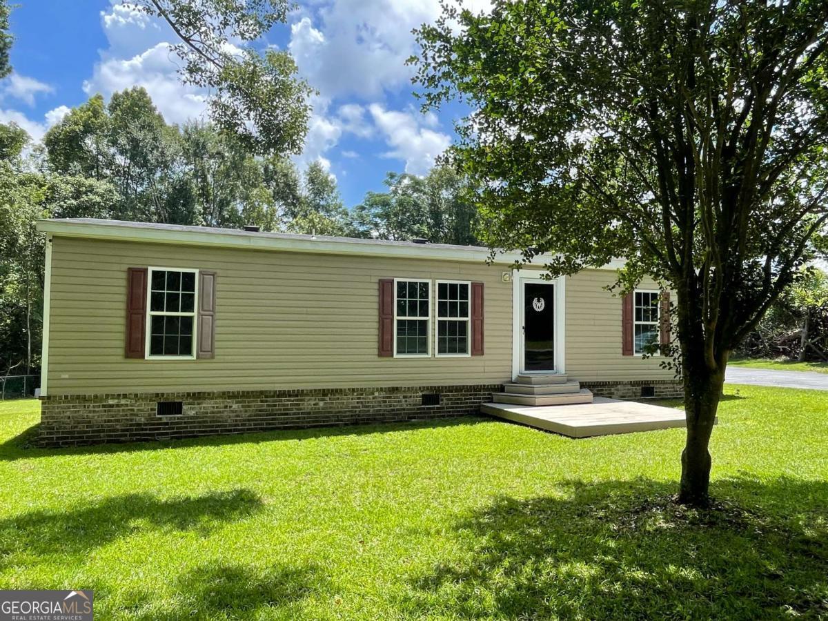 Discover this true gem in the heart of Glennville. A 3 BR 2 Ba mobile home with a thoughtfully designed split floor plan. The open-concept living room seamlessly connects to the dining area, creating an inviting space for gatherings and relaxation. The modern kitchen is equipped with appliances and ample counter space. Enjoy the outdoors under the 2-car carport, providing shelter for vehicles and additional storage. A separate storage building offers extra space for tools, equipment, or hobbies.