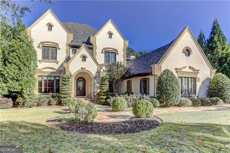 Incredible estate home in popular Rivers Call at Wildwood. This wonderful community offers a gated entrance with 24/7 gate attendant. Very private setting which backs to the Chattahoochee National Forest - completely private! This wonderful enclave neighborhood is located within great proximity to all the major interstates. This custom home was built by Panama Properties and the incredible attention to detail and second to none craftsmanship is evident from the moment you step into this incredible all all brick English Manor style home. The home features a room a for every need. The main floor features the primary suite which is removed from all the common areas allowing for complete privacy. The main floor features beautiful hardwood floors throughout. The beautifully paneled library with fireplace and built-in custom cabinetry makes for a great home office. Entertaining is made easy in this home with an oversized dinging room which connects to the gourmet chef's gourmet kitchen via a 'butler's pantry' area. The gourmet kitchen features top of the the line appliances, a nice breakfast area overlooking the private back yard and an extra large true walk-in pantry. Located just off the gourmet kitchen is an informal keeping room with vaulted ceiling and fireplace. Enjoy your morning coffee just off the breakfast 'room' area in the enclosed screened in porch. The beautiful formal living room with the third fireplace features a sensational wall of windows allowing an incredible amount of natural daylight to filter in. There are two laundry rooms - one on the main level and one on the second floor. The second floor features four complete en suites. There is also an extra spacious room which could easily serve as a homework center, home office or playroom. Two stair cases provide easy access to the upstairs level. Beautiful hardwood floors are found in the hallway areas upstairs. The terrace level is unfinished but has been framed to show a logical layout for a buyer to finish the way they would like. An over-sized three car garage has ample storage space for bikes and other items that need to be stored. No detail has been overlooked in this wonderful offering.
