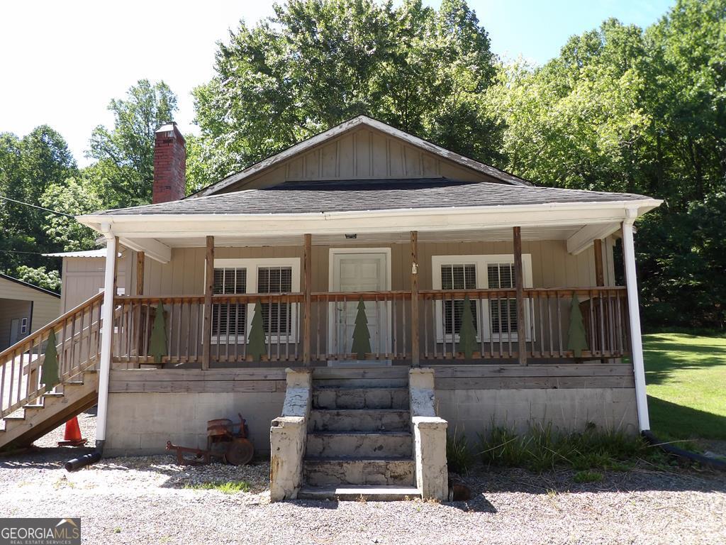 Unrestricted, residential or commercial property with highway frontage. 2,000 sq. ft. metal shop with automotive lift, numerous carports & out buildings. RV site with RV port and separate septic in place. Old home has had kitchen removed to make an antique shop which is now closed. Very easy to add kitchen and use property for residential occupancy. Property can be divided into four lots that have some great building sites for cabins or additional RV sites/tiny homes. Property has a county water meter in place but is operating off old well. The well is on adjoining property that has no problem with the well use but, if the well malfunctions, the property owners will want to switch to county water. There are numerous possibilities for this property.