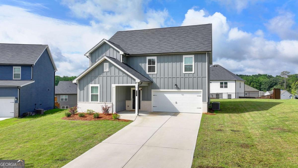 Discover the perfect blend of comfort, convenience, and modern living in this stunning Dawsonville home, located just 2 miles from GA-400 in the sought-after Dawson Grove community. Set on a north-facing corner lot at the end of a cul-de-sac, this property offers one of the largest yards in the neighborhood-providing both privacy and plenty of outdoor space to enjoy. Elevated on a premium homesite, the home boasts open, scenic views. Step inside and you'll be welcomed by the popular Jordan floor plan, featuring an open-concept layout designed for both everyday living and entertaining. The chef's kitchen showcases a large granite island, elegant white cabinetry, a full tile backsplash, and flows seamlessly into the great room with its dramatic floor-to-ceiling fireplace. Luxury vinyl plank flooring carries throughout the main level, bathrooms, and laundry for a sleek, low-maintenance finish. Upstairs, the spacious primary suite includes a walk-in closet and a private bath with a walk-in shower and linen storage. An oversized laundry room adds convenience for busy households. With five bedrooms in total-including a guest suite on the main level-there's space for everyone. This home is also about lifestyle. Families will appreciate the private community path to Blacks Mill Elementary, while outdoor lovers will enjoy nearby Dawson Forest mountain biking trails and Lake Lanier. Shopping and dining at the North Georgia Premium Outlets are just minutes away. The neighborhood itself offers sidewalks, streetlights, and a community pool with cabana. Don't miss your chance to own one of Dawson Grove's best homes-where space, style, and location come together beautifully.
