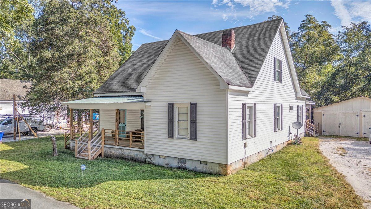 Charming, restored 1916 farmhouse in the heart of historic Covington! This 4 bedroom, 2 bathroom home offers over 2200 sq ft of updated living space with original hardwoods, high ceilings, decorative fireplaces, and a spacious owner's suite on the main level. The country-style kitchen features an oversized island, eat-in area, farmhouse kitchen sink, walk-in pantry/laundry, and connects to a brick-floor mudroom. Upstairs includes two large bedrooms, two bonus spaces, and an updated full bath. With a detached 2-car garage including storage, ample storage throughout the home, and classic Southern charm and original details throughout! Enjoy peaceful outdoor living on the covered front and back porches overlooking a fenced yard with stone fireplace, muscadine vines, pecan trees, and various fruit trees. Located in Covington's golf cart district, just minutes from the Square (home of Vampire Diaries, Heat of the Night, Walking Dead, Dukes of Hazzards filming and more), Cinelease's Three Ring Studios, I-20, Rivian plant, local parks, and the 14.25 mile Cricket Frog Trail (Covington's "Beltline").