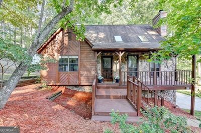 Welcome home to this lovingly maintained home by the same owners for the past 28 years! This home is truly move in ready - it's been freshly painted inside since the sellers moved out; the carpets have been cleaned; fresh mulch spread in the front and backyard; HVAC last serviced in July and thermostat replaced. The windows were replaced, and the deck was extended and partially covered in 2011; the kitchen and primary bathroom remodeled in 2015; upstairs carpet replaced in 2021 and primary bedroom carpet replaced in 2023; exterior of the house was repainted in 2023 and new garage doors installed in 2023 as well. This home offers the opportunity to own in award-winning Lassiter High School district, with a Roswell address (but lower Cobb County taxes), with no HOA. The stone accent on the exterior is the same stone as the floor-to-ceiling fireplace in the living room and is absolutely stunning in person. You'll also love the vaulted ceilings in the living room (with the incredible stone fireplace) and the primary bedroom which really make the rooms feel incredibly open. The sellers will tell you that they loved the home because it feels like a cabin in the woods, but right in the middle of Roswell. They loved the peace of the front porch, as well as the huge rear deck and the private, wooded view. One of their favorite spots was the swing under the deck and they've left the swing for the owners to fall in love with as well.