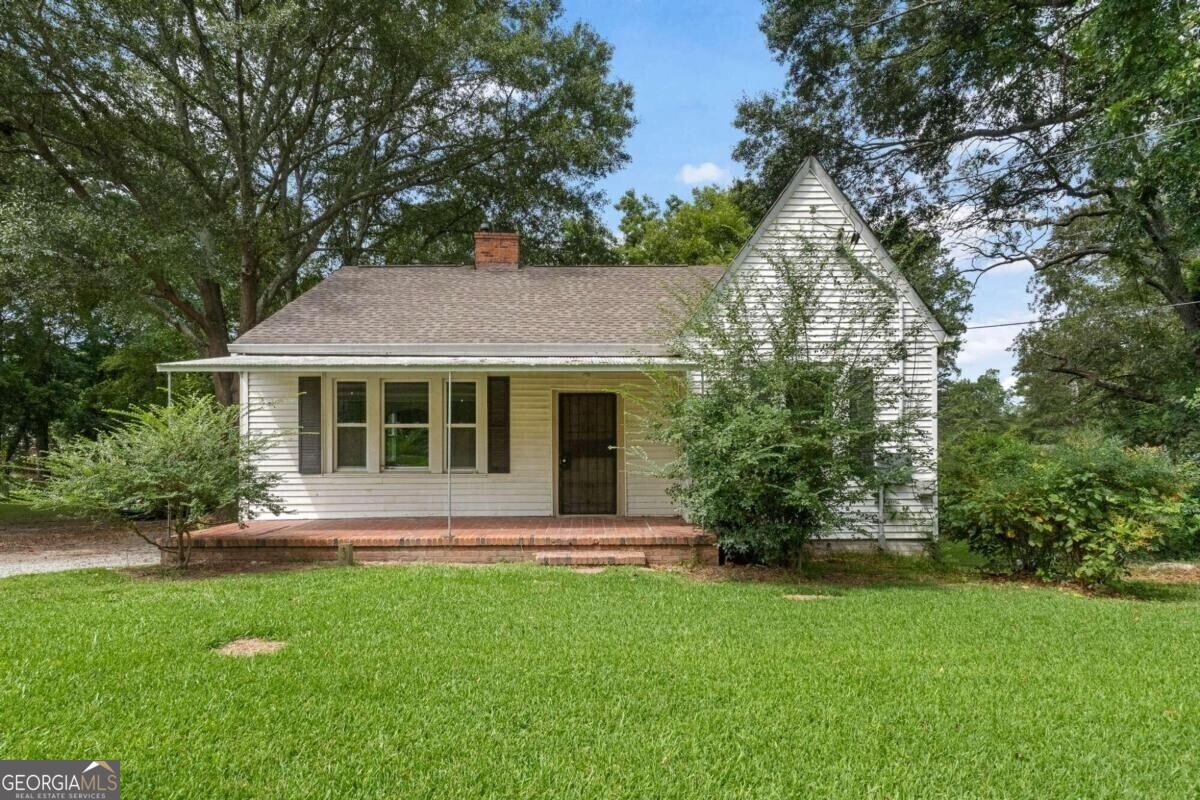 Amazing opportunity to have a slice of country so close to the city! Almost 1acre corner lot with 2 barn buildings and a sweet updated home. 2br/1ba w permanent stairs to expandable attic. Located off hwy 29/Main Street, this location is accessible to so much. Quiet street and picturesque lot w large tree for shade, gravel driveway, and home w old barn and another building. Home has been nicely updated with windows, insulation, hvac, water heater, beautiful kitchen and bath. View photos to see just how attractive the interior is! pretty kitchen cabinets, granite counters, washer/dryer connections in kitchen. Great floors and overall interior color scheme. Seller will install new AC unit at closing. No appliances included. Owner has never lived in home and is selling As Is. Perfect for owner occupant, or as a rental. Close to airport, I-85, and surrounding shopping.