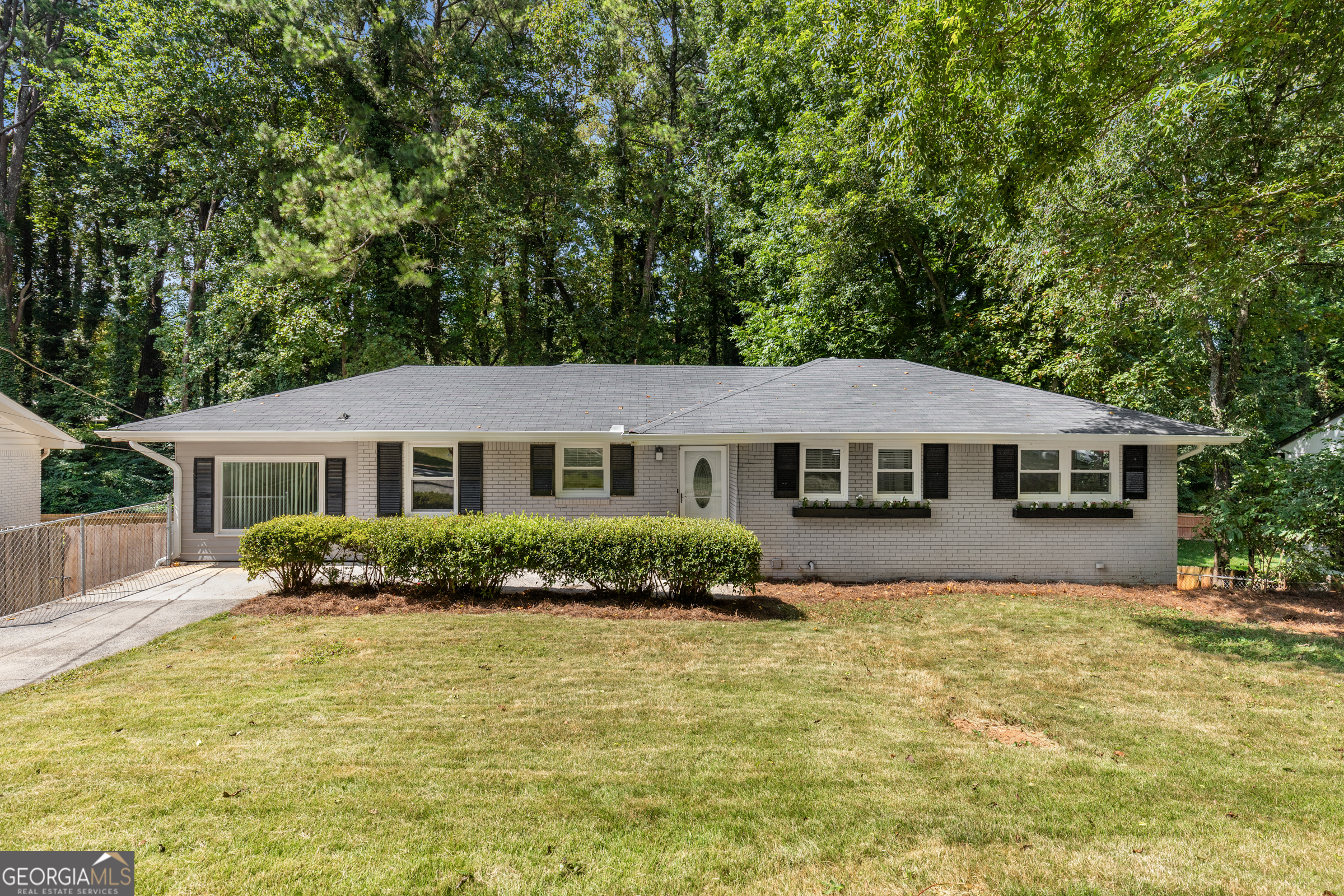 OPEN SAT 8/2 - 2pm - 5pm Recently updated 4 bedroom & two full baths and kitchen - with +1,100 square feet of partially finished basement space with a full bath provides room to grow and immediate home equity opportunity. The main floor of this mid-century 4BR/2BA ranch home boasts new marble-style quartz countertops, white shaker-style cabinets, new stainless steel gas range, dishwasher and microwave and refrigerator. New farm sink and tile backsplash. New wide-plank LVP flooring throughout the main floor, new lighting and ceiling fans along with fresh paint make this home move-in ready. ROOM TO GROW: LARGE UNFINISHED BASEMENT with a full bathroom, a fireplace and two additional rooms and a separate egress from the driveway make this home perfect for growing families or even an investor looking to create a separate living space for rent. PRIVATE BACKYARD - Enjoy large deck off the living room, overlooking the private backyard. Large carport and extra parking pad inside fenced back of home. NEIGHBORHOOD: Home is located in Creatwood Forrest - just 400 feet from Smyrna's newest park - Creatwood Park! Here you are only mins from downtown Smyrna, The Braves Stadium at The Battery, Cobb Galleria Mall and all the shops and entertainment Atlanta has to offer!