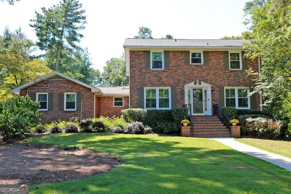 Beautifully maintained Brick traditional on corner lot in quiet neighborhood. This home has been renovated to add an additional 560+ sq. ft to expand the kitchen, breakfast room and family room. The beautifully updated kitchen has a cathedral ceiling, SS appliances including double ovens and smooth surface cooktop, custom cabinets, granite counter tops, a huge island and pantry. Large arched opening gives a great view to the oversized family room. The family room has built-in cabinets built-in seating with storage, a masonry wood burning fireplace with french doors leading to the separate living room. The large separate dining room is perfect for gatherings. The main floor also features a full bath with walk-in shower a large laundry room and multiple storage cloests/pantries. The updated Master Suite has bath with a tiled walk-in shower, large vanity and linen closet. 3 additional bedrooms up with 3rd full bath that has tub/shower combo and dual sinks. Finished daylight basement has a large media/flex room with built-in shelves, a wood burning fireplace, and plenty of additional storage. Large deck off kitchen over looks back yard and has been recently updated with composite decking. 3 sides brick with fiber cement siding in rear. 2 car rear entry garage with automatic opener. Outbuilding for storage. Close to parks, lake, shopping and walk to school!