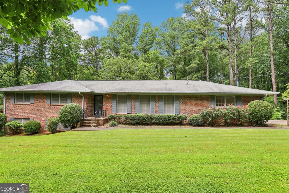 Welcome to 415 Haven Ln - a private and spacious sanctuary nestled on a serene 1.9-acre wooded lot in sought-after Marietta. This beautifully maintained 5-bedroom, 3-bathroom home offers the perfect blend of comfort, functionality, and natural beauty. Step into a light-filled living and dining room that immediately invites you in with warmth and openness. The thoughtfully designed kitchen overlooks a cozy fireside family room, creating the perfect setting for everyday living and entertaining. A sunroom at the back of the home showcases views of the private, wooded lot and offers a peaceful spot to relax and enjoy nature year-round. The primary suite is conveniently located on the main level, providing privacy and ease of access. The fully finished terrace level includes an in-law suite complete with two bedrooms, a full bathroom, its own kitchen, and a spacious living area - ideal for multigenerational living, guests, or rental potential. Step outside to a generous backyard that feels like your own private park. Multiple decks offer ample space for entertaining, dining, or simply soaking in the tranquil surroundings. A garden area and views of the nearby lake complete this idyllic outdoor setting. Don't miss this rare opportunity to own a versatile home with so much to offer - all just minutes from top schools, shopping, and dining in East Cobb.