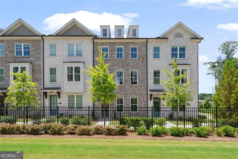 Better Than New - Spacious 3 Bed, 3.5 Bath Townhome Built in 2024. Welcome to this stunning, move-in-ready townhome offering the perfect blend of modern design, comfort, and convenience. This spacious home features 9-foot ceilings on all three levels, creating an open and airy atmosphere throughout.The terrace level includes a flexible bedroom or office space with a full bath-ideal for guests or a private work-from-home setup. As you step into the main floor, you're greeted by an open, light-filled layout perfect for today's lifestyle. The chef's kitchen features sleek quartz countertops and stainless steel appliances and flows seamlessly into the large fireside family room. Just off the family room, enjoy a generous deck-perfect for relaxing or entertaining. Upstairs, the third level offers a secondary bedroom with its own ensuite bath, plus a spacious primary suite with a spa-like bathroom. The laundry room is conveniently located on the same floor. Ideally situated just a mile from GA 400 and moments from the new Cumming City Center, Lake Lanier, and The Collection, this townhome provides an exceptional lifestyle with access to premier dining, shopping, and entertainment.