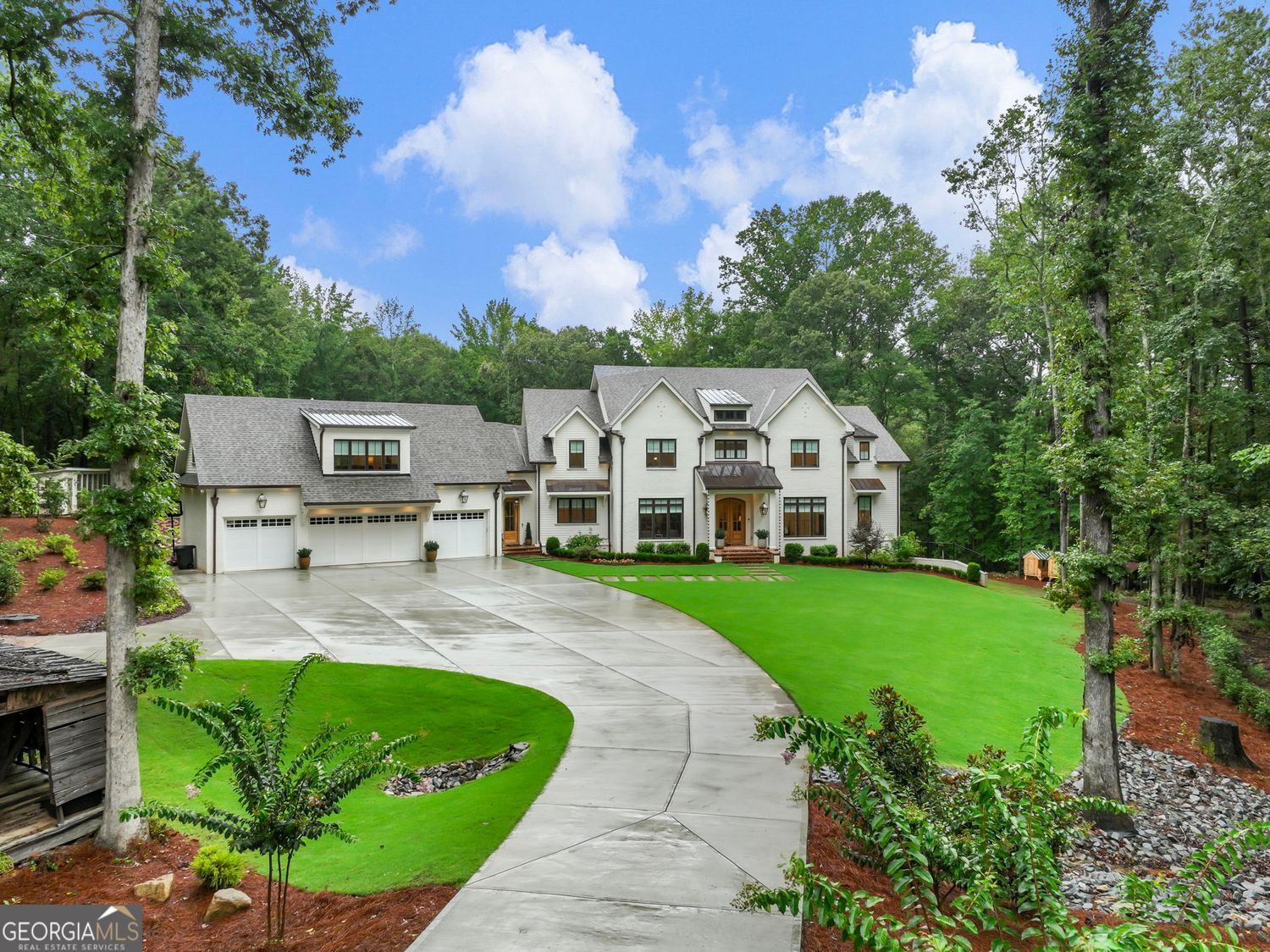 *RARE OPPORTUNITY IN BUFORD CITY SCHOOLS*. Completed in late 2023, this stunning 4-sided brick estate offers 7,900 finished square feet with an additional 3,800+ square feet of basement space. Sitting on a beautiful 2.69-acre homesite plus an additional 6 acres of recreational property. with Richland Creek frontage, the home includes a 4-car garage and an impressive 3,000-square-foot barn featuring 25 ft ceilings and oversized roll-up doors, one 14 feet high, and additional covered storage. Designed with exceptional craftsmanship, the home features real copper gutters, scuppers, downspouts, and numerous copper gas lanterns illuminating the entire front of the home. Built with spray foam insulation on all walls, ceilings, and the roof, this property delivers incredible energy efficiency. Inside, you'll find soaring 10-foot and higher ceilings, custom cabinetry with quartz countertops throughout, Visual Comfort lighting throughout, and rich white oak hardwood flooring on the main level. The chef's kitchen is a true showstopper with a paneled double refrigerator, high-end appliances, gold fixtures, beverage and wine coolers, a massive island, and a large butler's pantry with its own sink and icemaker. The open floor plan offers serene property views from the kitchen, dining, and living spaces. The master suite is unmatched, boasting a 24-foot cathedral shiplap ceiling and spa-quality finishes. Outdoor living is equally impressive with a spacious brick-covered porch, grilling porch, and plenty of room to add a pool. The completely sodded front, side, and backyards are professionally landscaped with mature trees and shrubs, fully irrigated with creek water, and include both wooded and open spaces ideal for gardening or recreation. A private guest suite with living area and bath is located above the garage. The long concrete driveway leads to a 4-car garage with a rear drive-through door and an expansive flat parking area for guests. With city sewer service and thoughtful high-end finishes throughout, this estate offers rare privacy, elegance, and functionality-all within the highly sought-after Buford City School district. Buford City Schools were recently named the #1 SCHOOLS IN THE NATION for academics, college prep, and student support. Families love the new Buford High School, complete with a state-of-the-art campus and an impressive new stadium that showcases the community's commitment to top-tier education and athletics.
