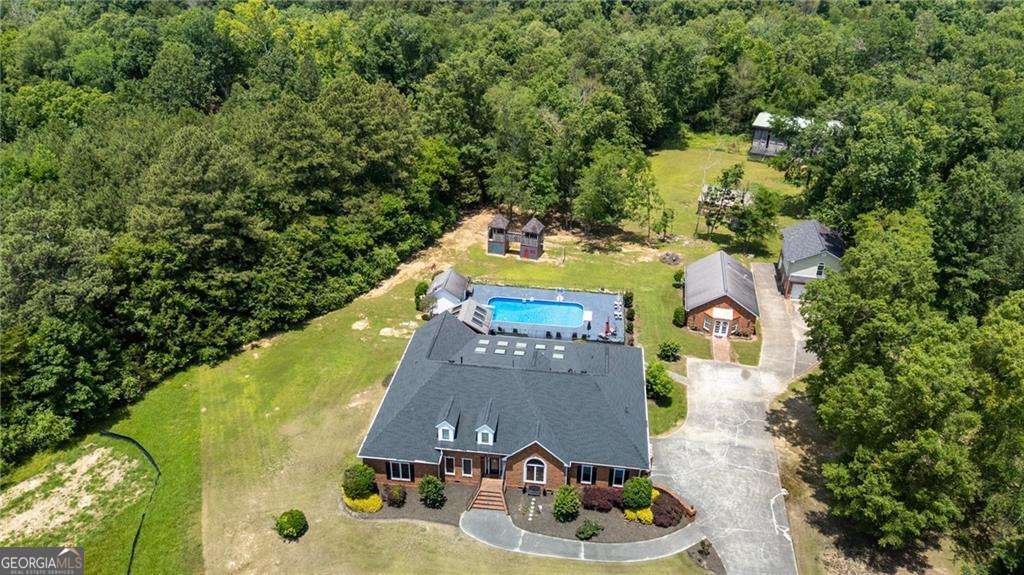 ***Highly motivated sellers due to job relocation. The home and property are in excellent condition. All reasonable offers will be thoughtfully considered.*** Exquisite Brick Estate on Acreage in a Coveted Neighborhood Setting. Discover the perfect blend of elegance, space, and functionality in this stunning brick estate, nestled on expansive acreage while still offering the warmth of a neighborhood setting. Located in a highly sought-after school district, this exceptional home provides everything you need and more. Inside, the gourmet kitchen is a chef's dream, featuring solid wood cabinetry, granite countertops, a spacious island, two stainless steel refrigerators, two dishwashers, three sinks, two warming drawers, and a gas cooktop. The breakfast bar and breakfast room create the perfect space for casual dining. Upon entering the grand foyer, you'll be welcomed by a sophisticated office and an elegant dining area. The main living space is bathed in natural light, offering an inviting atmosphere for relaxation and entertaining. This home also boasts two laundry rooms, 3 additional large rooms upstairs and a private gym for ultimate convenience. Additional highlights include a separate full mother-in-law suite, a detached garage with spacious living space and a bathroom adding additional finished square footage to this amazing property, a hot tub pavilion with a like-new hot tub, a pool room, and a dedicated workshop area. The chlorine/salt pool has been recently updated with a new pump, new diving board, and a new liner, ensuring years of enjoyment. The barn studio workspace is ideal for creative projects or additional storage, while the greenhouse is perfect for gardening enthusiasts. Surrounded by beautiful landscaping, this estate is as picturesque as it is functional. Meticulously maintained and incredibly spacious, this home offers an abundance of room for comfortable living. This estate is a rare find...don't miss the opportunity to make it yours!