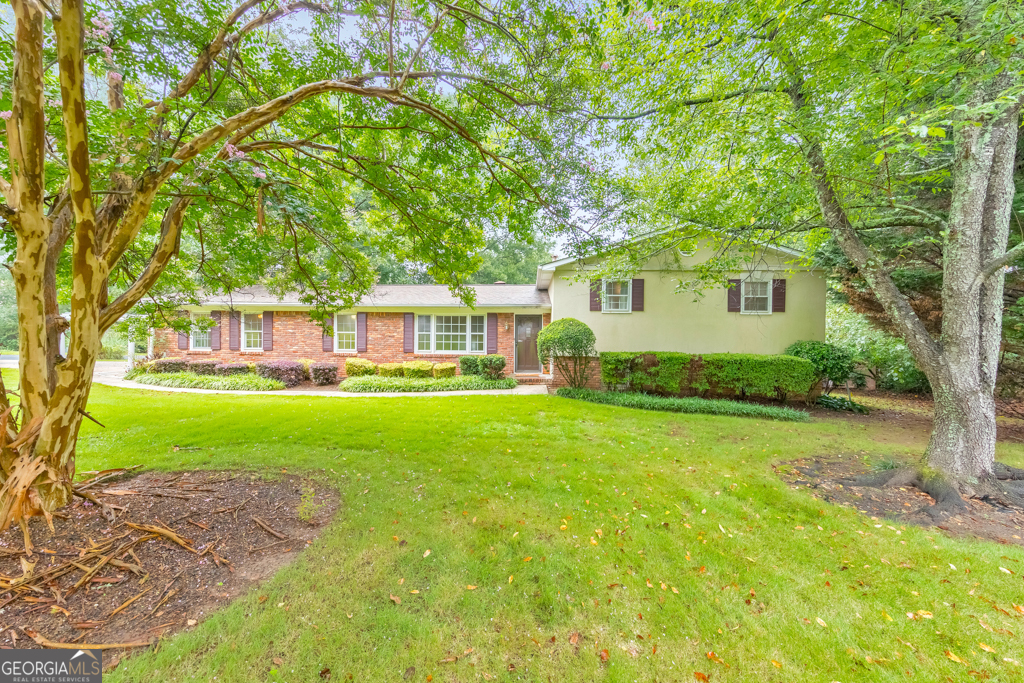 Nestled on a spacious corner lot in the Addison / Simpson / Sprayberry / Lassiter School district. This stunning updated split-level home features 4 bedrooms, 2 full bathrooms, plus a bonus room, perfect for an exercise room, home office, or additional bedroom. The layout includes a large living room with a cozy fireplace, a custom kitchen featuring a convection oven, a dining area, and a sunroom overlooking the spacious backyard. The upper level features the primary suite with a custom walk-in closet and an additional bedroom. Downstairs, there are two additional bedrooms, a bonus room, and a large laundry room. Outdoors, enjoy plenty of greenspace with a built-in sprinkler system and entertain friends and family on a custom deck, two gazebos, hot tub, and patio complete with its own tiki bar. For those needing a private office, there's finished space in the detached 1.5-car garage with its own driveway. Abundant storage options include storage buildings, a fenced outdoor storage area, and a gardening shed. Come see this unique property located near great schools, shopping, restaurants, and more!