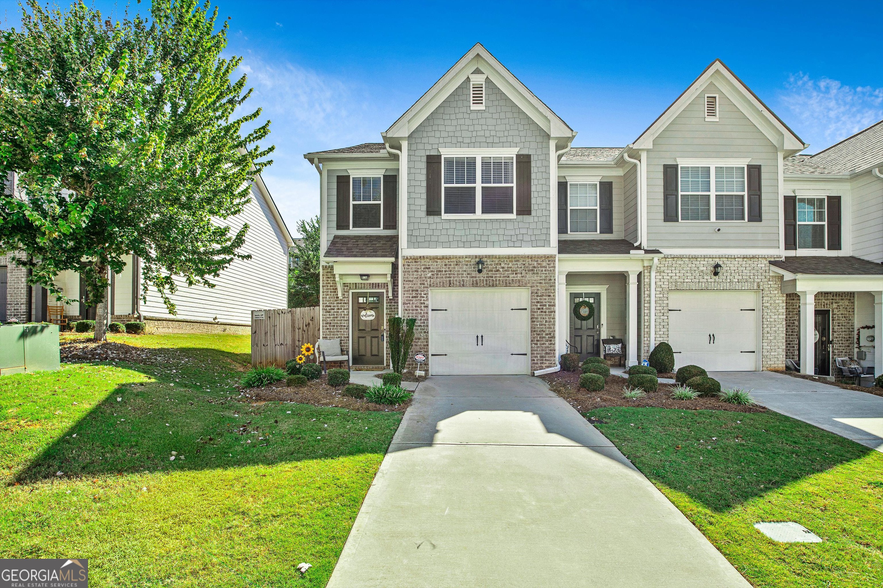 Move right into this pristine, like-new end-unit townhouse, ideally situated near Ashley Park shopping, Downtown Newnan, and offering convenient access to the Atlanta airport. The LINC trail is a half mile away, perfect for outdoor enthusiasts! The interior is well maintained and features a fenced backyard for added privacy. Throughout the home, upgraded luxury vinyl plank flooring has been installed-no carpet in sight. All windows are outfitted with blinds and drapes - the washer, dryer, and refrigerator are included with the sale. The main level presents an open-concept floor plan encompassing a dining area, living room, kitchen, and a powder room. The kitchen is well-appointed with granite countertops, a tasteful tile backsplash, breakfast bar, stainless steel appliances, a pantry, and a built-in microwave. The dining area is enhanced by an elegant chandelier, while the living room offers a ceiling fan and a tile-surround, remote-controlled fireplace. A door leads to a private, fenced backyard and patio area, ideal for outdoor entertaining. The primary suite features a spacious walk-in closet, tray ceiling, and a luxurious private bathroom with a double vanity, separate shower, water closet, and two linen closets. Two additional bedrooms, each equipped with ceiling fans, share a full bathroom located in the hallway. The laundry room is conveniently situated upstairs, alongside pull-down attic stairs providing additional storage space. Additional highlights include a kitchen-level entry one-car garage with an automatic opener, integrated smart home technology including a garage opener, doorbell, and thermostat. Lawn maintenance (excluding the fenced area) and select exterior maintenance are included with the HOA fee. The HOA fee is low-about $70 a month. See this beautiful home before it's gone!