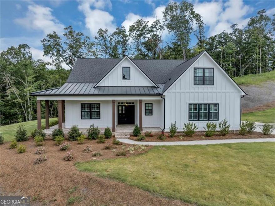 Welcome to 388 Oxford Road-an exquisite Ball Ground estate designed to impress at every turn. This residence exudes refined luxury with soaring ceilings, expansive living spaces, and seamless flow built for both grand entertaining and everyday elegance. The chef's kitchen stands as the centerpiece, featuring professional-grade appliances, custom cabinetry, and a statement island that anchors the open-concept design. Retreat to the owner's suite, a private sanctuary with spa-inspired amenities and boutique-style closet. Secondary bedrooms offer generous scale and designer finishes, ensuring comfort with sophistication. Outdoors, expansive grounds set the stage for elevated living-perfect for al fresco dining, future resort-style amenities, or simply enjoying the serene surroundings. Positioned in one of Ball Ground's most coveted enclaves, this showcase property offers unmatched style, privacy, and presence.