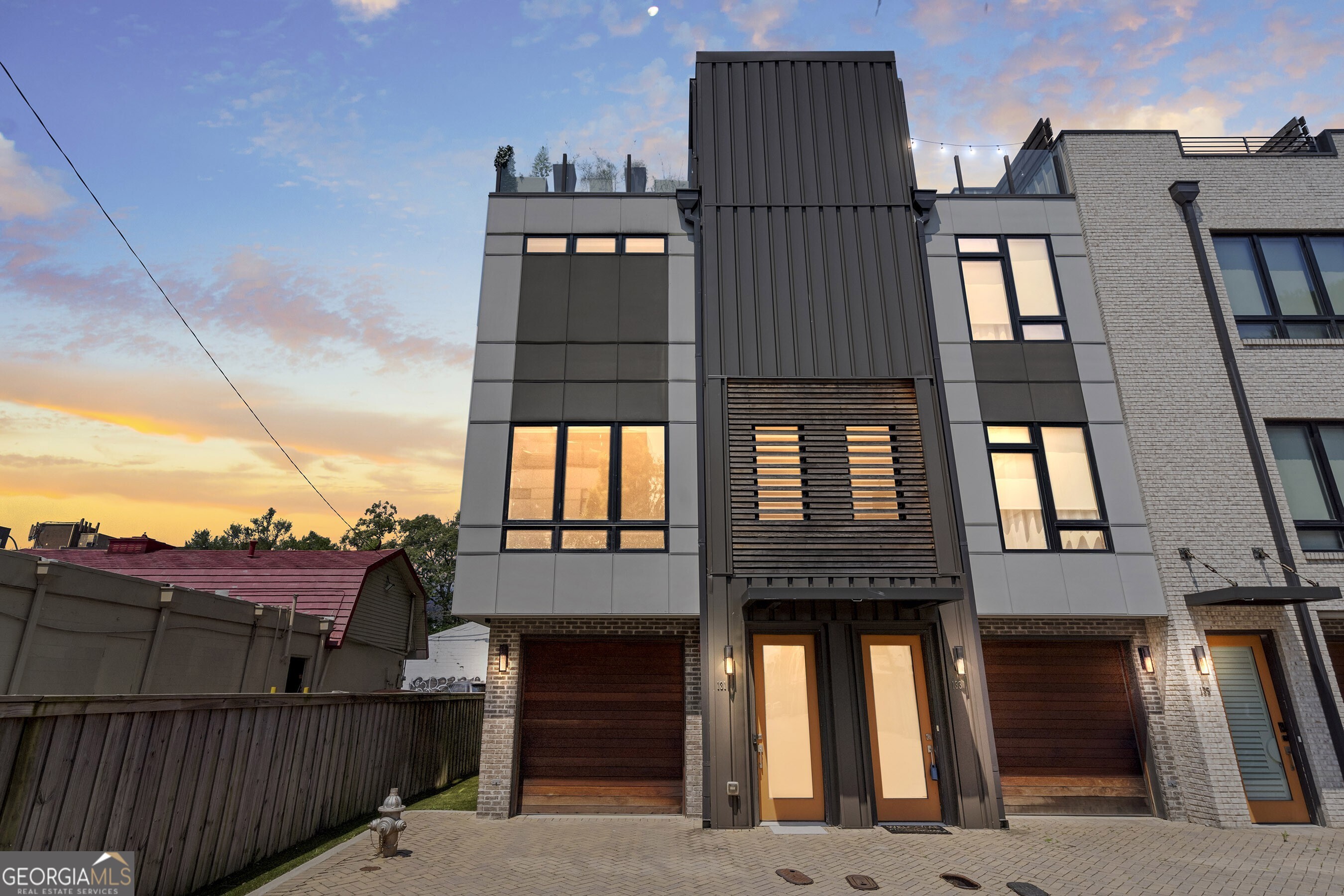 This stunning end-unit townhome at Views at Old Fourth Ward offers an ideal blend of luxury, design, and convenience in one of Atlanta's most sought-after locations. As the largest floor plan in the community at 1,915 sq ft, this home stands out with thoughtful upgrades and high-end finishes throughout. Featuring three spacious bedrooms, premium appliances, and elegant design, this property is made for those who appreciate both style and functionality. The gourmet kitchen is equipped 36" Wolf range and high end stainless steel appliances, waterfall quartz countertops, and a custom tile backsplash perfect for culinary enthusiasts. The interior is elevated with resilient modern wood floors, custom closets throughout the home, and epoxy-coated custom garage flooring, adding layers of sophistication and convenience. The owner's suite serves as a private retreat, complete with a spacious bathroom, walk-in closet, and luxurious finishes. Upgrades include a tankless water heater for on-demand hot water and enhanced energy efficiency. The versatile top floor can be used as a bedroom or flexible living space and includes a full bathroom and access to a private rooftop deck. This rooftop oasis features a custom wet bar, hookups for a gas grill, wine cooler and ice maker, offering the ultimate setup for entertaining or unwinding while enjoying sweeping views of the city. Enjoy convenient access to one of the largest fenced backyards in the Views @ O4W, featuring a spacious patio for outdoor entertaining and relaxing in total privacy. A fully fenced backyard that is low-maintenance, located just off the tandem two-car garage, offers the ideal space for your resident pup to play safely and securely. The attached garage is already plumbed for water supply and drainage, making it a strong candidate for conversion into a functional fourth bedroom, potentially with an en-suite bathroom. Ad advantage of being an end unit is extra parking space for guests. The Views @ O4W is ideally located just 0.6 miles from Piedmont Park and only two blocks from Ponce City Market/Beltline, this home is also close to Whole Foods, Kroger, Forum Athletic Club, and beloved local coffee shops offering a perfect blend of luxury, walkability, and convenience. Low HOA fee of $250/month, which has remained unchanged since construction in 2019. The HOA covers exterior structure, roof, windows, landscaping, irrigation, lighting systems, and all improvements on common property. The community consists of 27 units. Currently, several units are available to be leased. This home is truly a city dweller's dream, offering the ultimate urban lifestyle in one of Atlanta's fastest-growing and most vibrant Intown neighborhoods. Furniture is negotiable.