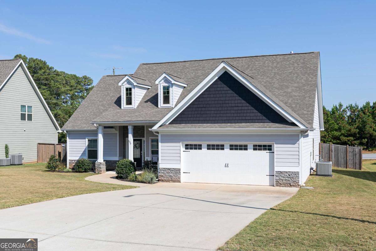 Built in 2020 and meticulously maintained, exceptional home truly outshines new construction with its thoughtful upgrades and attention to detail. Step onto the charming rocking-chair front porch and into the inviting foyer, where you'll immediately appreciate the gorgeous builtin's, hardwood flooring, elegant lighting, and the bright, open floor plan-perfectly designed for both entertaining and everyday living. The main level offers a formal dining room highlighted by wainscoting, crown molding, and a tray ceiling, setting a refined tone for special gatherings. At the heart of the home, the chef's kitchen impresses with abundant soft-close white cabinetry, granite countertops, a stylish tile backsplash, under-cabinet lighting, stainless steel appliances, a walk-in pantry, and a breakfast bar overlooking the sunny breakfast room. The kitchen flows seamlessly into the dramatic two-story family room with hardwood floors and a cozy stone fireplace. Just steps away, a covered back porch overlooking the large fenced backyard, creates the perfect spot for morning coffee, quiet evenings, or entertaining family and friends. The luxurious owner's suite is conveniently located on the main level and features a tray ceiling, ceiling fan, walk-in closet, and a spa-inspired ensuite bath. Relax in the soaking tub or refresh in the separate tiled shower, with double vanities, soft-close cabinetry, and tile flooring adding both beauty and function. Two additional bedrooms, a full bath with granite countertops and tile flooring, and a laundry room complete the main floor. Upstairs, you'll find an oversized fourth bedroom retreat with two walk-in closets and a spacious full bath featuring granite countertops, soft-close cabinets, and tile flooring-ideal for guests, teens, or a private home office. Beyond the home, enjoy fantastic neighborhood amenities including a sparkling pool, playground, and covered mail center. Conveniently located near WC Abney Elementary, restaurants, shopping, grocery stores, and parks, this home offers both comfort and convenience.