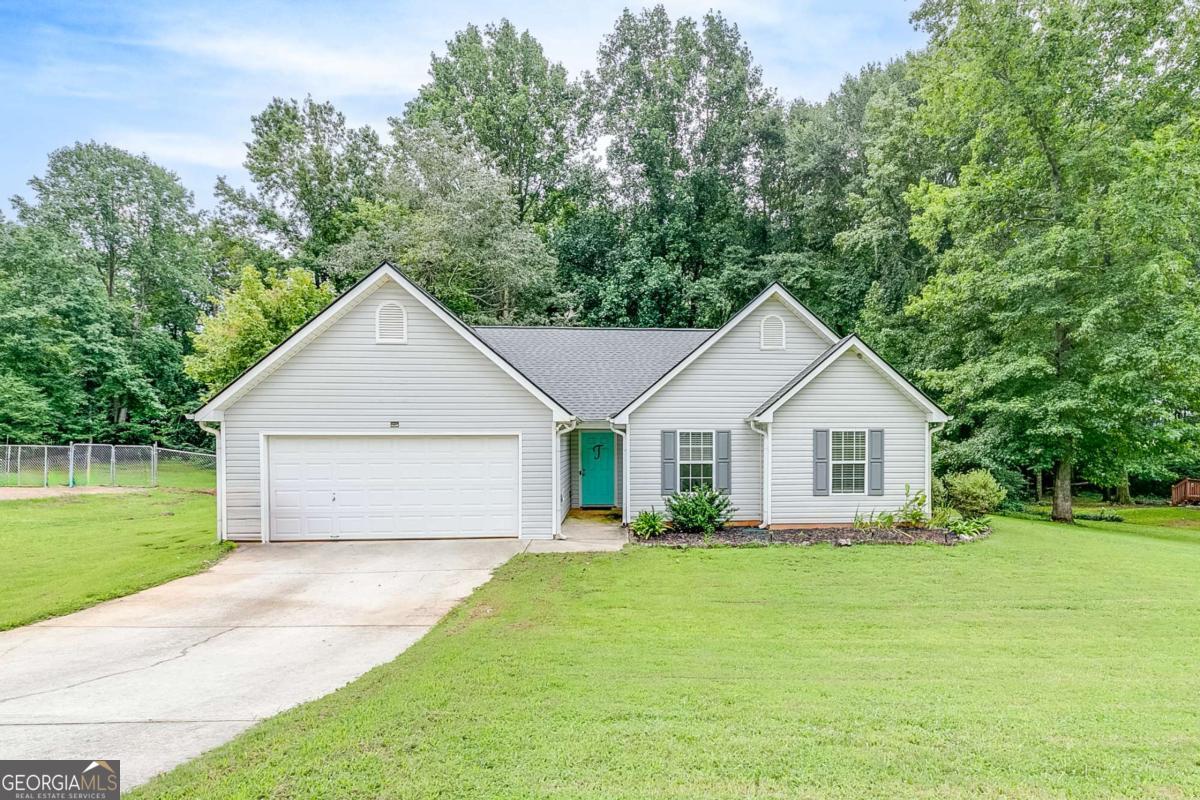 Welcome to this charming 3 bedroom, 2 bath home situated on a spacious .95-acre lot in the quiet Riverwood subdivision-a small, one-street neighborhood with no HOA. This home offers the perfect blend of comfort, style, and convenience. Inside, you'll find luxury plank flooring throughout and a bright, open layout. The kitchen features painted cabinets and connects to the dining area with sliding glass doors leading to the back deck-ideal for entertaining or enjoying a peaceful morning coffee. The living room boasts vaulted ceilings, abundant natural light, and inviting farmhouse-style paint colors. The primary suite is a true retreat with its trey ceiling, plentiful natural light, and a spacious bathroom complete with a large double-sink vanity, walk-in shower, separate soaking tub, and ample storage. Outside, the property features a fenced backyard with mature trees and shrubs, plus a grassy front yard. With low-maintenance vinyl siding and a location that's conveniently nestled between Jefferson and Commerce, this home offers both practicality and charm. Don't miss your chance to own this move-in ready home in a peaceful, tucked-away setting!