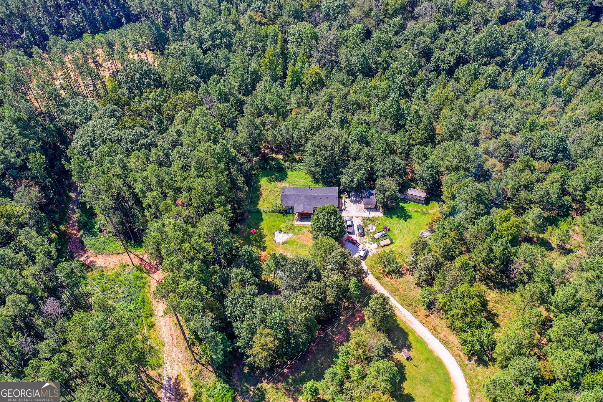 This approximately 2,001 square foot house sits on an expansive 10.31-acre lot, offering a spacious and private setting. The home features an open floor plan with abundant natural light and vaulted ceilings, creating a bright and airy atmosphere. This home has been completely renovated! The three bedrooms, including a spacious primary bedroom, provide ample living space, while the two bathrooms feature elegant finishes and spacious vanities. The kitchen boasts ample cabinetry and storage, with a layout designed for efficiency and convenience. A spacious laundry room, walk-in pantry and a practical mudroom entry provide functionality and organization. Outside, the property is surrounded by lush greenery, creating a peaceful and secluded setting. The covered porch offers a tranquil spot to enjoy the serene, wooded environment. The expansive yard and grounds provide ample space for various outdoor activities and hobbies, including two detached structures that can be used as a home office, workshop, etc. This property offers a unique blend of comfortable living, abundant space, and a private, natural setting, making it an ideal choice for those seeking a peaceful and versatile living environment.
