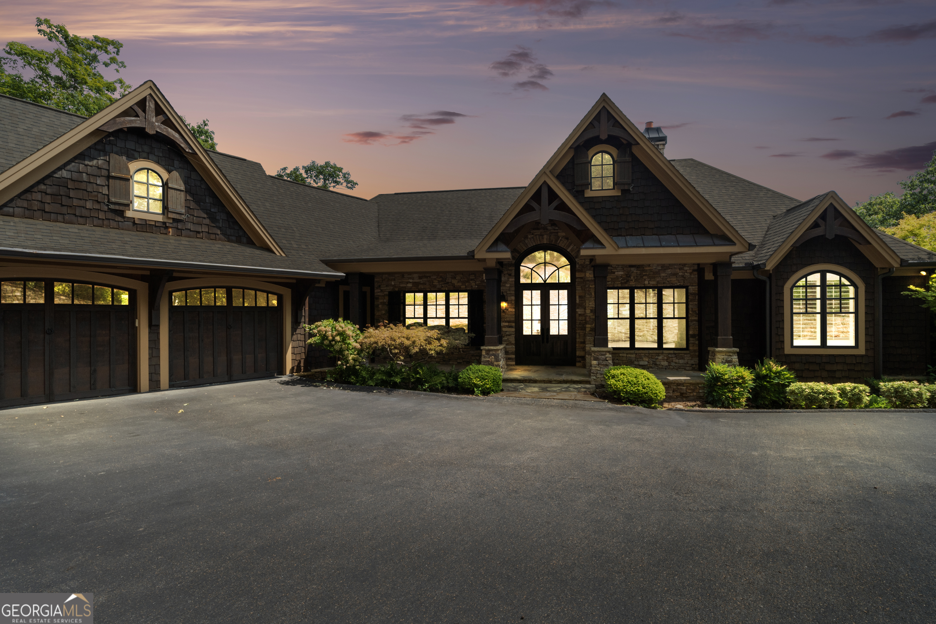 Luxurious Cox Mountain Retreat with Sweeping Panoramic Views is ready to be yours. Perched at the summit of Cox Mountain, this extraordinary 4-bedroom, 3.5-bath executive residence delivers awe-inspiring 180-degree vistas, from the shimmering lights of Atlanta to the rugged profile of Stone Mountain. Built in 2010 with exceptional craftsmanship, every detail of this custom home reflects timeless mountain elegance. From the moment you arrive, the home's commanding presence draws you in, rich cedar shake siding, stone accents, arched windows, and a welcoming front entry framed by lush landscaping and soft evening lighting. With timeless craftsmanship, the residence showcases soaring cathedral ceilings with exposed beams, 8-foot solid doors, custom millwork, and designer finishes throughout. The open-concept great room centers around a dramatic floor-to-ceiling stacked stone fireplace, while the gourmet kitchen impresses with premium appliances, custom cabinetry, a spacious island, and breakfast bar, ideal for both everyday living and entertaining. A separate living room, three stacked stone fireplaces, a full wet bar, built-in safe, and billiard table offer endless spaces for gathering. Hardwood floors grace both the main and terrace levels. Additional thoughtful touches include a screened-in porch for year-round enjoyment, multiple expansive decks designed to capture the panoramic views, and a professionally landscaped driveway edged with a stacked stone wall and integrated lighting. Outdoors, relax in the jacuzzi hot tub under a canopy of stars or enjoy the private dog run. Perfectly positioned just minutes from the Post Office, Clubhouse, and main gate, this home combines privacy with convenience to all of Big Canoe's premier amenities. A rare opportunity to own one of the community's finest homes-schedule your private tour today!