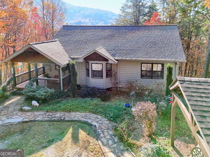 Welcome to your private mountain sanctuary , nestled in the city limits of Clayton. The charming cabin offers a unique opportunity for short-term rental income or cozy mountain living. This Beautifully maintained retreat offers a rare blend of peaceful seclusion, mountain views, tons of added details and modern comforts, all within minutes of local shops, hiking trails, and Rabun County's best outdoor adventures.  Enjoy end of road privacy, Set on a generous 1.3 acre wooded lot this charming home features over 2280 square feet of thoughtfully designed living space. The main level boasts a spacious layout with vaulted ceilings, hardwood floors, and a stone  fireplace-perfect for cozy evenings or entertaining guests.  The kitchen with its vibrant blue tile countertops, stainless appliances and breakfast area complement the main level perfectly.  Wake up to mountain views in the primary bedroom with ensuite bathroom.  Step outside on  the  grilling deck and enjoy the quiet while soaking in the  mountain views.  An additional Bedroom and guest bath on the main level and 2 additional bedrooms and 2 baths downstairs with additional Family room/office.  Outside a custom designed workshop offers a great space for the handyman or crafter.  Whether you are looking for a tranquil escape or a lucrative investment opportunity, this property offers the best of both worlds. Only minutes to all the farm to table restaurants, shops, galleries, 3 state parks, hiking boating, fishing, etc, this cabin will put you and your guests at the center of it all!