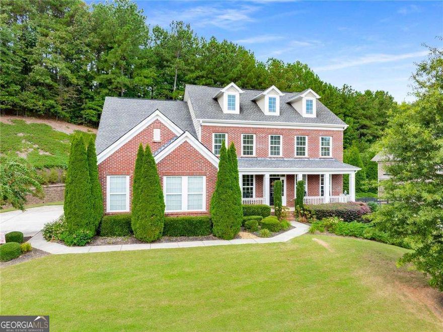 Welcome to 107 Millstone Manor Court-a beautifully maintained traditional home in the heart of Woodstock. Built in 2013 and boasting 5 bedrooms and 3 full bathrooms across 3,276 square feet, this residence combines timeless curb appeal with modern updates. Three sides of brick, fresh exterior paint (including the deck), and newly landscaped flower beds create a warm first impression, while the lush new sod in the backyard sets the stage for outdoor enjoyment.    From the inviting front porch, step into an open, light-filled foyer flanked by a formal dining room and traditional living room-perfect for gathering with loved ones and creating lasting memories. The main floor showcases hardwood floors, fresh neutral paint, and a guest suite with a full bath, offering comfort for overnight visitors or multi-generational living. At the heart of the home, the two-story family room impresses with a dramatic wall of windows and a floor-to-ceiling stone fireplace, filling the space with warmth and natural light. Overhead, the iron-baluster stairwell and catwalk add architectural character and an elevated sense of design.     Blending warmth and functionality, the chef's kitchen offers rich wood cabinetry, gleaming granite countertops, a custom tile backsplash, stainless steel appliances, and a generous walk-in pantry, along with a cheerful eat-in area for casual meals. With clear sight lines into the family room, the kitchen is ideal for both everyday living and entertaining. A functional drop zone and laundry room off the garage add daily convenience.    Upstairs, the deluxe primary suite is a true retreat with a private sitting area, a spa-inspired bathroom complete with a new glass shower door, and an oversized walk-in closet. Three additional bedrooms and another full bath provide flexibility for family, guests, or a home office.  The full daylight basement-already plumbed for a bathroom-offers endless possibilities, from a playroom or media space to a future guest suite.  Outdoors, the large freshly painted deck is perfect for grilling, relaxing, or stargazing and overlooks nearly half an acre of green space. Surrounded by flower beds and brand-new sod, the backyard is ready for your next cookout or quiet evening at home.    Located within walking distance of Arnold Mill Elementary and just minutes from Downtown Woodstock and Roswell, this home is also zoned for Mill Creek Middle and River Ridge High School. Here, comfort, convenience, and character come together in a place designed for making memories.    Buyer Incentive Alert: Ask about our preferred lender program offering a 1% lender credit and wholesale interest rates-an exclusive opportunity to make this beautiful home even more affordable.