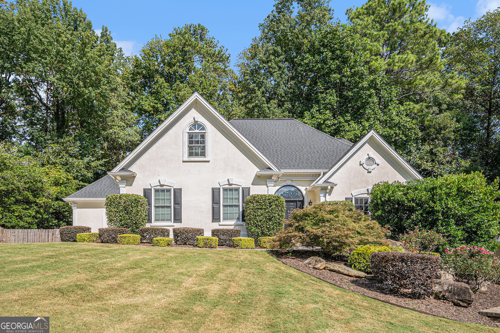 Welcome to this 5-bedroom, 4.5-bath home in the desirable Bristol Oaks community near Historic Roswell. This prime location offers easy access to shops, restaurants, Roswell parks, the Chattahoochee River, and major highways. The home features a spacious two-story foyer and a bright living room with abundant natural light. The master on main suite boasts a custom closet and a fully renovated bathroom with an oversized garden tub, frameless glass shower, and granite double vanity. The kitchen is equipped with stainless steel appliances, refaced cabinets, sliding shelves, and spacious pantry, with an adjacent sunroom and a brand-new deck perfect for outdoor entertaining. Notable updates include new hardwood floors on the main and upper levels, luxury vinyl in the basement, fresh paint throughout, a new HVAC system on the main and lower levels, and a brand-new electrical panel. The finished basement, complete with a separate entrance, bathroom, and accordion door separation, offers flexible space that can serve as an in-law suite. Exterior improvements include EZ Breeze windows and doors on the porch, expanded and repaved driveway, new garage door, freshly painted exterior, and a 40-year roof with skylight. The professionally landscaped front and backyard are enhanced with lighting, retaining walls, stone steps, and irrigation. This move-in ready home is located in a swim and tennis community served by excellent schools.