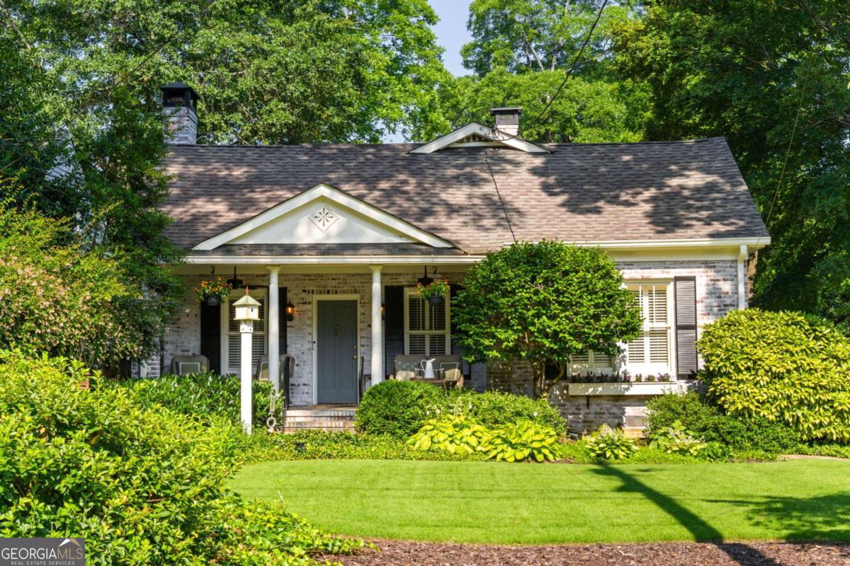 Step back in time with this charming 1920s home, perfectly situated just blocks from historic Marietta Square. Imagine starting your weekend with a stroll to the local farmers market, watching fireworks from your own front lawn on the 4th of July, immersing yourself in year-round festivals, and enjoying all the dining, shopping, and community events that make the Square so beloved. Inside, this four bedroom, two bath home radiates warmth and character with original hardwood floors, millwork, and a gas log fireplace. The kitchen is a true heart of the home - a space that invites you to simmer a pot of soup or savor your afternoon tea. Outfitted with classic white cabinetry, new walnut butcher block counters, quartz-topped custom island, and abundant natural light, it's a kitchen where memories are meant to be made. The primary suite occupies the second level and offers a private retreat with a full bath, while the finished lower basement level provides flexible space for a home gym, media room, or casual hangout - plus ample storage. Outdoors, the charm continues with a beautifully landscaped yard, a welcoming front porch perfect for morning coffee, and a detached two-car garage. This is more than a home. It's a lifestyle steeped in history, community, and everyday comfort, all within steps of the vibrant Marietta Square. Additional upgrades and features include: Updated light fixtures, new interior paint, new HVAC system with EcoBee thermostats, tankless water heater, new garage doors and wall panels, and full irrigation system with new front sod.