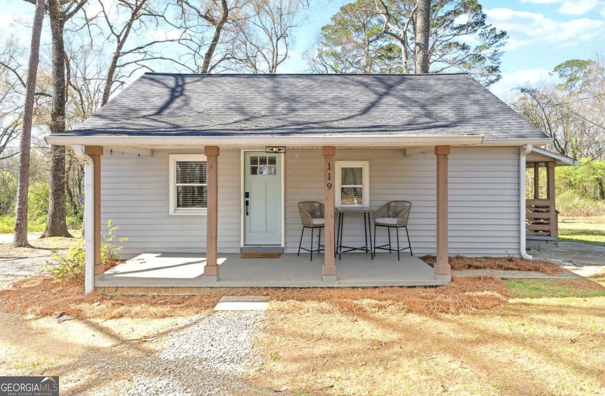 Don't miss this beautifully updated home, fully remodeled to combine classic charm with modern convenience. From the moment you're welcomed by the oversized rocking chair front porch, you'll appreciate the thoughtful upgrades and inviting layout. Step inside to a stylish open-concept living space with kitchen featuring white shaker cabinetry, quartz countertops, stainless steel appliances, and a breakfast bar that opens into the dining and living areas-perfect for entertaining or everyday comfort. Both bedrooms offer private ensuite access to the updated bathroom, complete with a modern vanity and sleek fixtures. Throughout the home, you'll find durable LVP flooring, contemporary lighting, and a convenient laundry closet. Major systems have been updated (2022), including a new roof, HVAC, plumbing, and more, giving you peace of mind for years to come. Enjoy the spacious, level lot, ideal for gardening, outdoor living, or future expansion. A large parking area can accommodate multiple vehicles with extra room for an RV, boat, or trailer. Centrally located between Atlanta and popular North Georgia (approximately 40 miles to either), this home is just 1 mile from I-575 and minutes to shopping, dining, and everyday conveniences. Furnishings negotiable. Added Bonus: Take advantage of the two neighboring homes also available for sale- and create the ultimate family compound!
