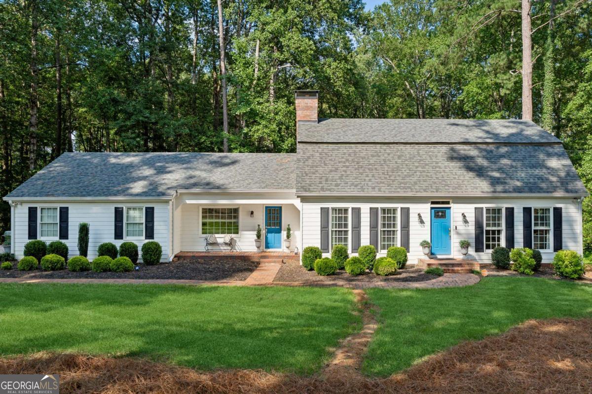 Welcome to this stunning home in the highly sought-after Charlotte Estates, perfectly situated on nearly 2 private acres and zoned for top-rated Milton schools. Just minutes from downtown Crabapple and Alpharetta, this home blends classic charm with modern updates throughout. Step inside to find a spacious, light-filled floorplan featuring a primary suite on the main level and three secondary bedrooms upstairs. With four fully renovated bathrooms showcasing custom vanities and beautiful tile work, this home offers luxury and comfort at every turn. The main level features refinished hardwood floors and an updated kitchen with white shaker-style cabinetry and modern appliances. Enjoy outdoor living on the screened-in back porch, perfect for relaxing or entertaining. Upstairs, you'll find updated carpet, while the full, partially finished basement includes luxury vinyl plank flooring and plenty of space for storage or expansion. Outside, the property offers a large wooded lot with plenty of level green space, ideal for outdoor activities, gardening, or future pool plans. Additional upgrades include a roof, siding, gutters, garage door, lighting, hardware, and water heater-making this home truly move-in ready. Enjoy privacy and nature while staying close to vibrant shopping, dining, and community events in downtown Crabapple and Alpharetta.