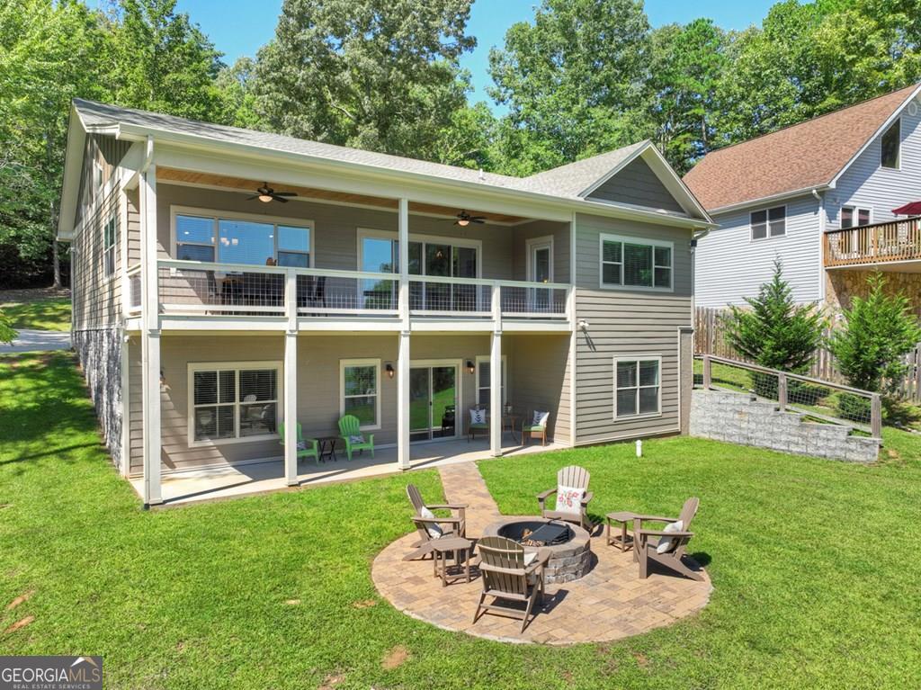 ^DISCOVER THE LAKE LIFE^ This Lake Nottely home offers all the features & amenities of a place to call home or your home away from home. Open concept living featuring 4BR's, 2.5BA's totaling over 3,600 sq. ft. of living space. All rooms are oversized making this the perfect house for entertaining family & friends. Primary en-suite on main level featuring separate soaking tub & walk in tile shower, double vanities & huge walk in closet. Large covered porch spans entire front of home overlooking this amazing lake & mtn. view. Nice front yard with gentle slope to the waters edge is the perfect yard for kids & pets to enjoy. Enjoy the convenience of the lakeside pavilion which is great to store the lake toys in & floating boat dock included. Fire pit just off terrace is a great spot to relax & unwind in the evenings. Finished terrace level features 3 additional BR's, Media/Recreation Rm/Den & UF storage space & mechanical room + one unfinished room great for workshop or flex space. From the moment you step through the front door you get "lake vibes" seeing the lake directly through the windows across front. Cathedral ceilings w/ accented dark stained beams in the living, kitchen, dining area, gas log FP in LR, hardwood floors throughout & open staircase adds to the warmth of this lake front home. Custom upgrades throughout including lighting & plumbing fixtures + more. Conveniently located near Blairsville and Blue Ridge making this a great investment & prime location w/ all paved road access & concrete driveway w/ lots of parking. Well maintained & priced to sell. Schedule your appt. to see today because this one won't last long. Home has been professionally staged by Nathan Fitts & Team, North Georgia Home Staging, LLC. Furnishings, decor, accessories may be purchased separately via a Bill of Sale.