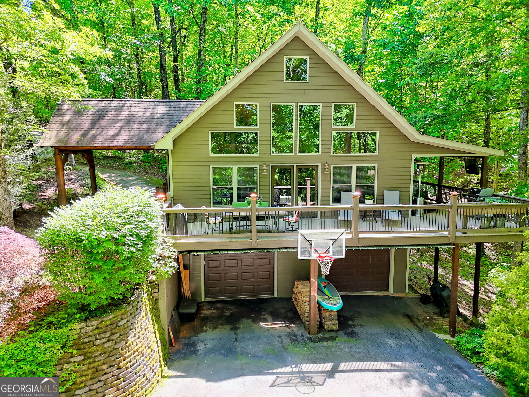 Discover Your Dream Mountain Retreat: Exquisite Home in Chinkapin at Lake Burton - Welcome to unparalleled living in the heart of the beautiful North Georgia Mountains! Nestled within the exclusive, small gated community of Chinkapin at Lake Burton, this stunning 3-bedroom, 3-bath home at 177 Whitetail Trail offers an extraordinary lifestyle where a beautiful forest surrounds you, and long-range winter mountain views become your seasonal backdrop. This is more than a home; it's a sanctuary defined by natural beauty, serene moments, and a vibrant community. Step inside and be captivated by the open-concept living area, where soaring ceilings and elegant hardwood floors create an expansive, inviting atmosphere. A cozy fireplace anchors the great room, which seamlessly flows to a large deck and a covered porch, all framed by the lush forest and a wall of windows that invite year-round sunshine. The home is designed for both grand entertaining and intimate family moments. The well-appointed kitchen, with its direct connection to the living area and wall of windows, is perfect for entertaining while enjoying the serene surroundings. Each of the three levels offers a private bed and bath with a sitting area, ensuring comfort and separation for family and guests. The walk-out terrace level boasts a versatile space. Outdoor living is paramount here, with multiple deck areas, including covered and uncovered spaces, perfect for morning coffee or simply enjoying the peaceful forest. Evenings come alive around the huge fire pit on your 1.76 acre private lot, ideal for campfires and s'mores under a starlit sky. Practical amenities include a unique pull-through carport porte cochere and a double garage on the walk-out basement level, providing ample parking for all your guests. Living in Chinkapin means easy access to the best of Lake Burton and the surrounding region. You're just moments from LaPrades Marina and Anchorage Marina, offering endless opportunities for boating, fishing, and water sports on Lake Burton, Lake Rabun, and Lake Chatuge. Explore the renowned Hemlock Falls and the legendary Appalachian Trail, with waterfalls, lakes, and rivers around every corner. The prestigious Waterfall Club is right next door, and the area boasts other private and semi-private golf courses. Enjoy the charm of Clayton, GA, a small town community with an abundance of activities for every age, including wonderful restaurants, concerts, shopping, local farmers' markets, and entertainment. It's close enough to town for convenience, yet just far enough off the beaten path to feel like a serene suburban community. Experience all four seasons, from sunshine to snow, in this truly special North Georgia haven. Hiawassee, GA, the home of the Georgia Mountain Fair, is about 25 minutes away and a great place for recreation and events. With its serene forest setting, seasonal mountain views, thoughtful design, and prime location, this Chinkapin home is ready to be your ultimate mountain escape.