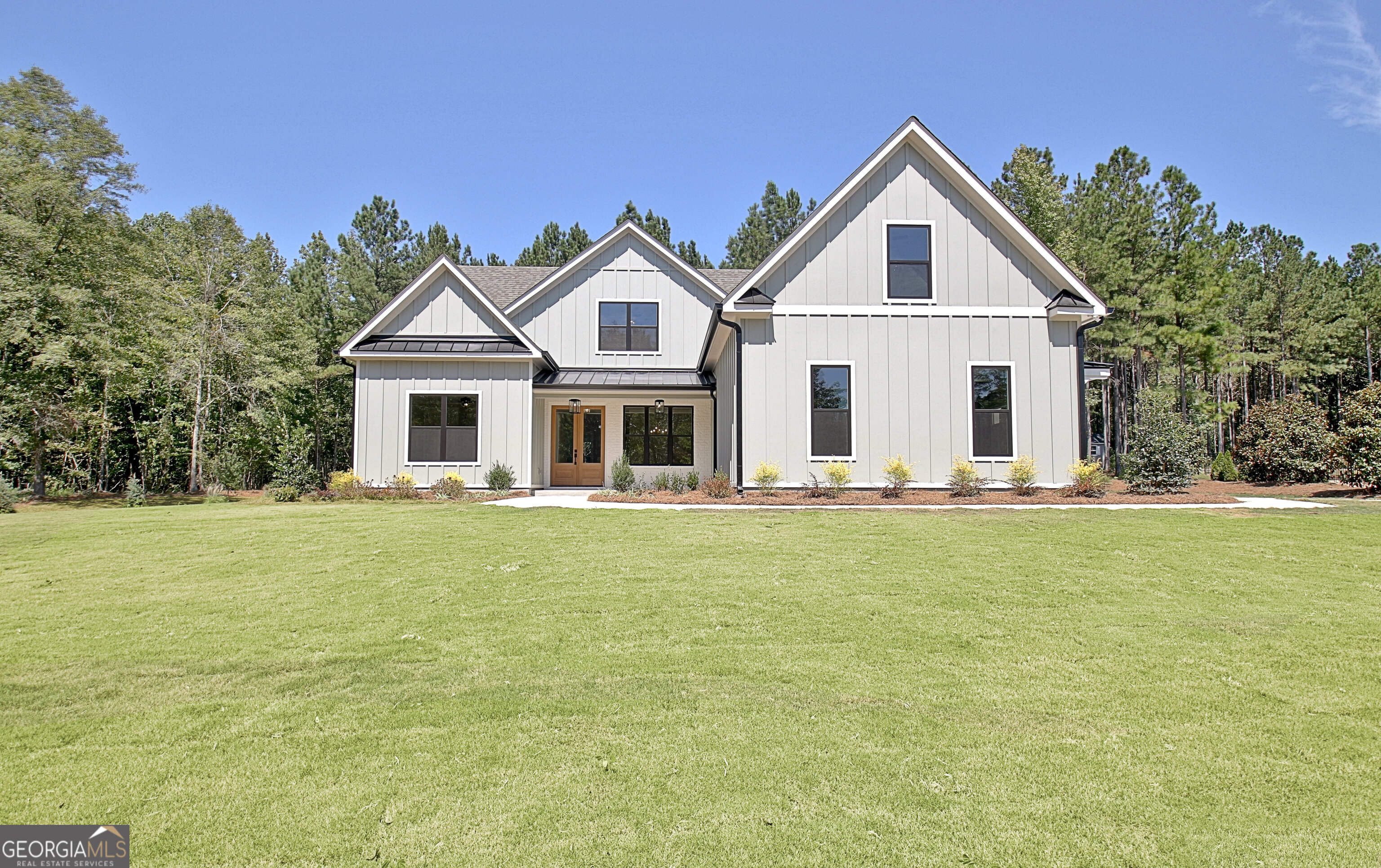 Exclusive NEW CONSTRUCTION home in The Reserve at Kelly Lake is almost complete! Sitting on 5 ACRES in desired Brooks community, this custom home showcases superior design and a contemplative layout. Dague Communities newest home, built amongst a tranquil setting, brings striking curb appeal to Grace Hope Drive with Board and Batten Hardie Siding, Metal Roof, Black Windows and a Covered Front Porch with Painted Brick accent. Grand Double Door Entry opens to Dining Room adorned with a twelve-grid accent wall and broad Foyer which leads to Guest Room/Office on Main. Adjacent Full Bath reveals a Tiled Tub Surround, Vanity with Quartz top, Moen fixtures and Hardwood floor. Great Room boasts a Vaulted Ceiling with Stained Wood Beams and a Floor to Ceiling Painted Brick Gas Start Fireplace with Wood Mantle. Kitchen offers Soft-close Timber and Dove colored Shaker Cabinetry with Brushed Gold Hardware, Island with Microwave and Trash/Recycle Drawer, Custom Vent Hood, Quartz Countertops, Tiled Backsplash, Under Cabinet Lighting, Large Breakfast Area and expansive custom Walk-in Pantry. Cafe Stainless Steel Appliance package includes Double Wall Oven, Cooktop, Dishwasher, and Microwave Drawer. Breakfast Area overlooks Game Day Porch with Outdoor Fireplace, and wooded acreage. Extended Primary Suite on Main, situated in the rear of the home, features low profile coffered ceiling. Lavish En-suite Bath features Raised Double Sink Vanity with Quartz Top, Chandelier, Freestanding Tub, Zero Entry Tiled Shower with Corner Bench, Niche and Handheld Shower Wand, Separate Water Closet, plus Generous Walk-In Closet with Custom Wood Shelving. Upper level provides massive Bonus room and Two En-Suites with Walk-In Closets; one revealing a light-filled private bath with geometric mosaic tile tub surround and the second revealing hardwood floors, art deco floor tile and hallway access. *Site Finished Hardwoods *Designer Lighting Package *Custom Trim Package with Crown Molding and Wood Shelving in all closets *8' Doors on main *8" Baseboards *Lever Door Handles *Attic Storage *Custom Drop Zone Conveniently located off Garage *Laundry Room on Main with Direct Access to Primary Suite *Hardie Siding* Black Metal Awnings, Gutters, and exterior Windows *Covered Front Porch w/ Double Entry Doors *Professionally Landscaped Yard *Irrigation with Drip System in Beds *Spray Foam Insulation *Septic strategically placed for future pool potential *Island Pendants and Frosted Glass Pantry Door Coming Soon!