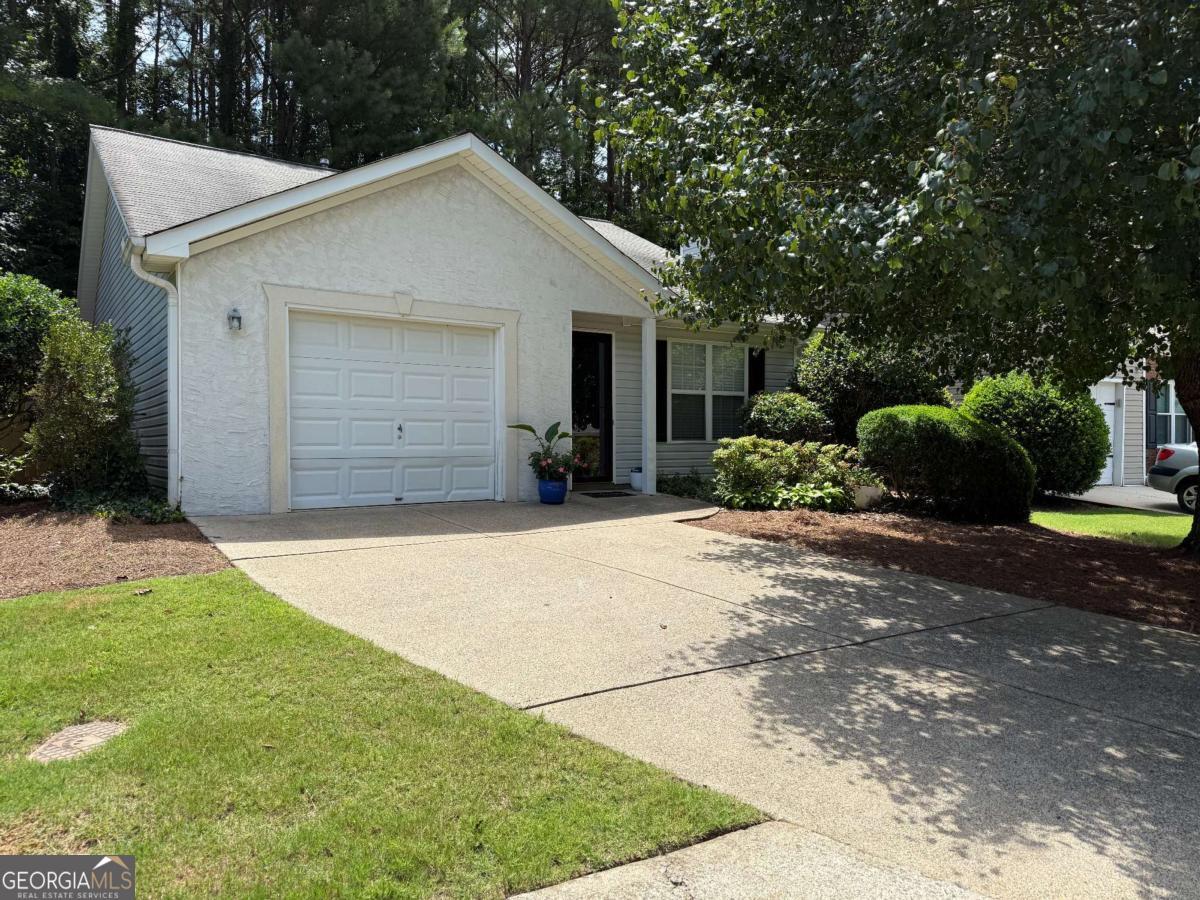 This well-maintained 2-bedroom, 2-bath home offers 888 square feet of comfortable, one-level living on a level lot with an attached one-car garage. Step inside to find durable Luxury Vinyl Plank (LVP) flooring throughout, complemented by a neutral painted interior that creates a bright and inviting atmosphere. The open-concept layout seamlessly connects the living and dining areas, making it ideal for entertaining or simply enjoying everyday life. The kitchen is equipped with a gas range and ample cabinetry, providing both function and convenience. Both bedrooms are filled with natural light. The primary suite features its own private bathroom, while the secondary bedroom is just steps from the full hall bath. Enjoy the ease of low-maintenance living- the HOA handles front yard mowing, and the side and backyard require little to no upkeep. Located just 4 miles from vibrant Downtown Woodstock and only 1 mile from Hobgood Park, you'll love the convenience of nearby shopping, dining, and recreation. Zoned for highly rated schools: Bascomb Elementary, E.T. Booth Middle, and Etowah High School. A charming home or a great rental investment, this delightful property checks all the boxes. Don't miss your chance to make it yours!