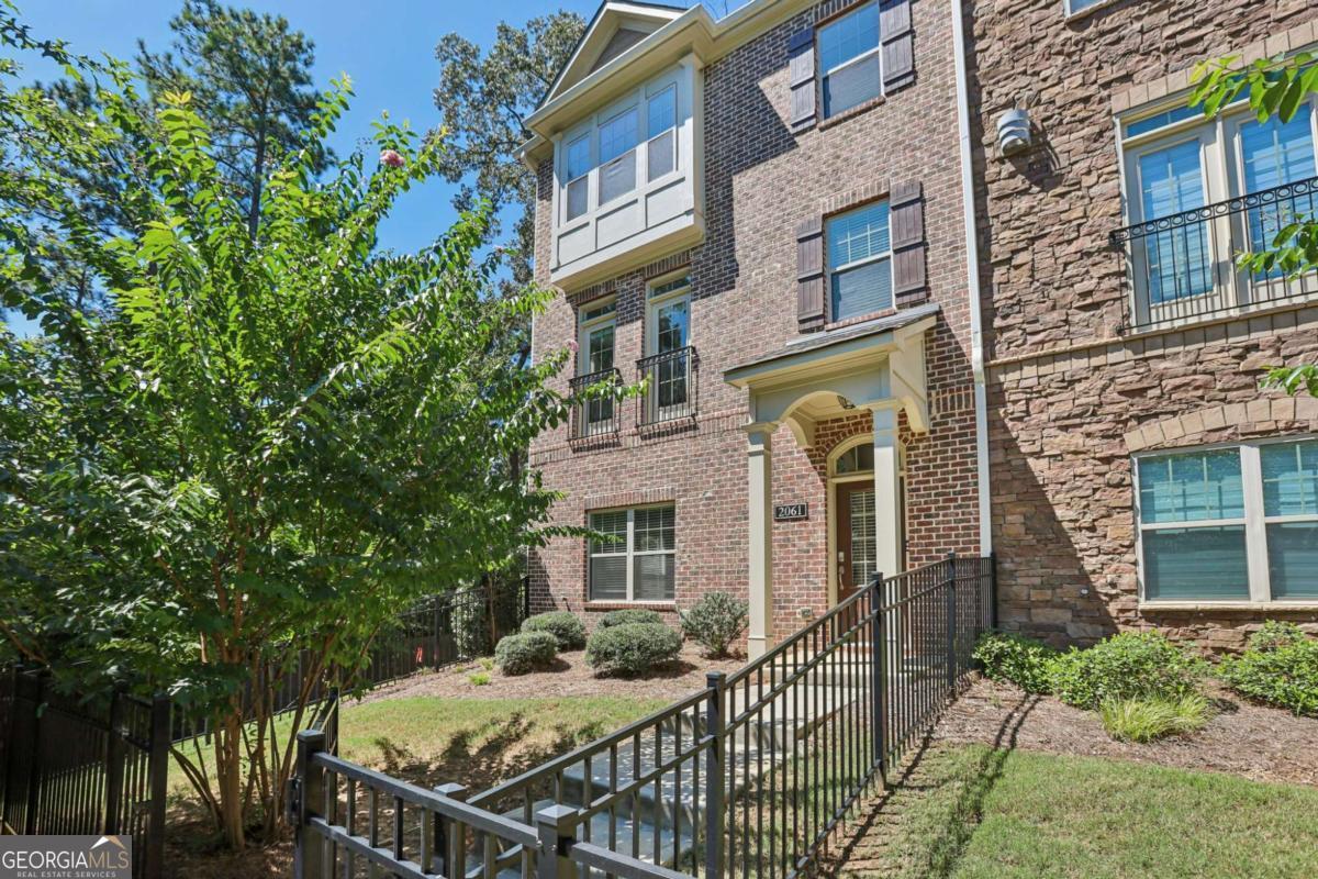 Beautiful Move-In Ready Townhome in Gated Community! This bright corner-unit townhome offers the perfect blend of style, function, and convenience. A private gated entry and front yard welcome you inside. The first floor features wood floors, a bedroom with a full bath-ideal for guests or a home office-and access to the two-car garage. Upstairs, the open-concept main living area features a light-filled living room with a fireplace, a modern kitchen with an oversized island, stone counters, tile backsplash, stainless steel appliances, and a dining area with balcony access. On the third floor, the spacious primary suite includes a tray ceiling, walk-in closet, and spa-like bath with dual sinks and an oversized fully tiled shower with bench. Two additional bedrooms, a full bath, and a convenient laundry room complete the level. Enjoy outdoor living on your private balcony or at the community greenbelt with fire pit and pool. Located near shopping, dining, and with easy highway access, this home truly has it all!