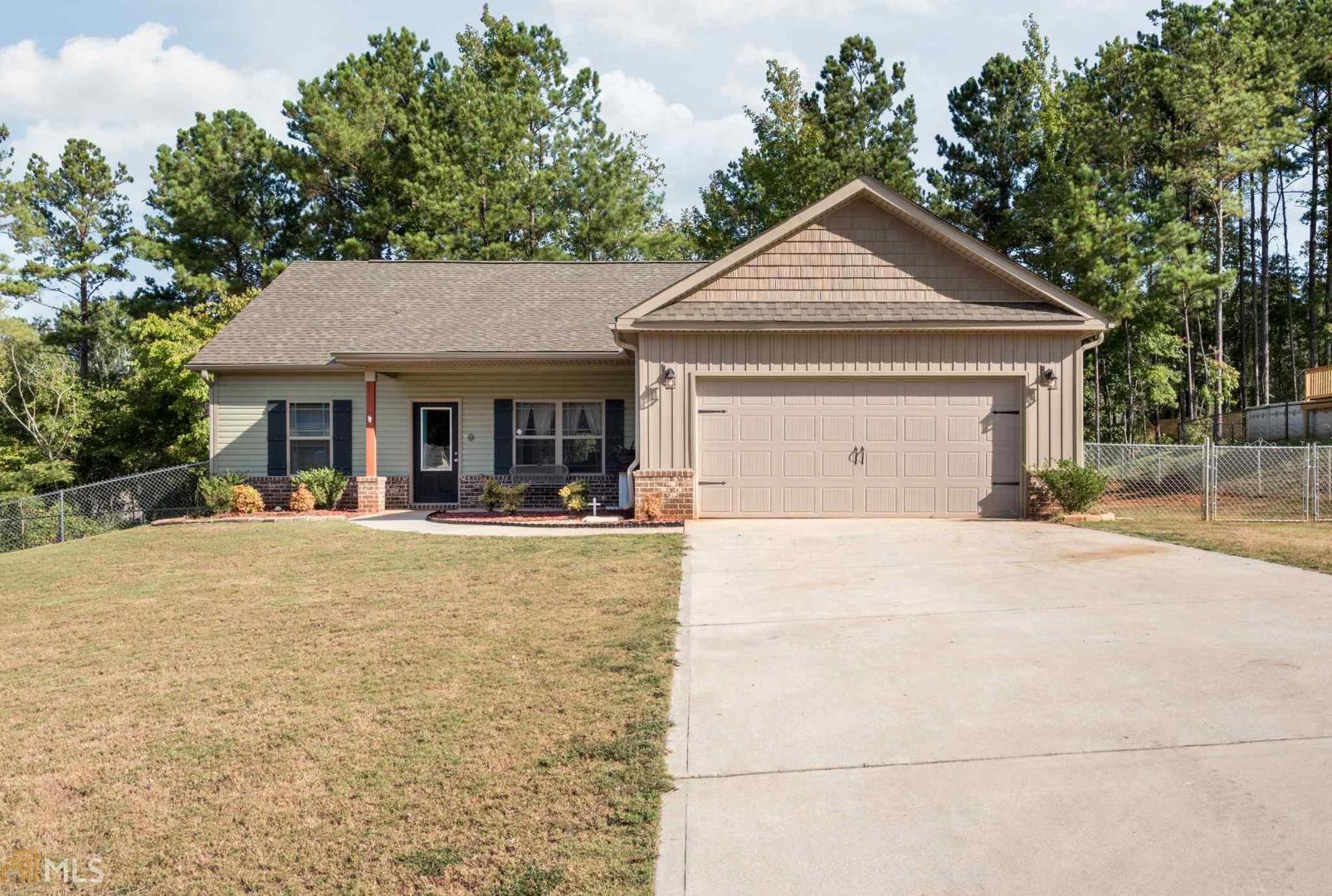 ONLY 2 YEARS OLD! Lovely 3 bedroom/2 bath Craftsman-style home in Autumn Ridge. Luxury vinyl wood-grain flooring adorns the living/dining room, kitchen, and baths with carpet in all the bedrooms. Kitchen has stainless steel dishwasher, range, and microwave, modern espresso cabinetry w/42" wall cabinets, and a breakfast bar. Master bedroom has trey ceilings and ceiling fan. Master bath has a garden tub, separate shower, raised vanity w/dual sinks, and HUGE walk-in closet. Gliding glass doors lead from living room to the beautiful covered patio and outdoor fireplace. Fenced back yard. 2-car garage. Close to Spalding County High School.