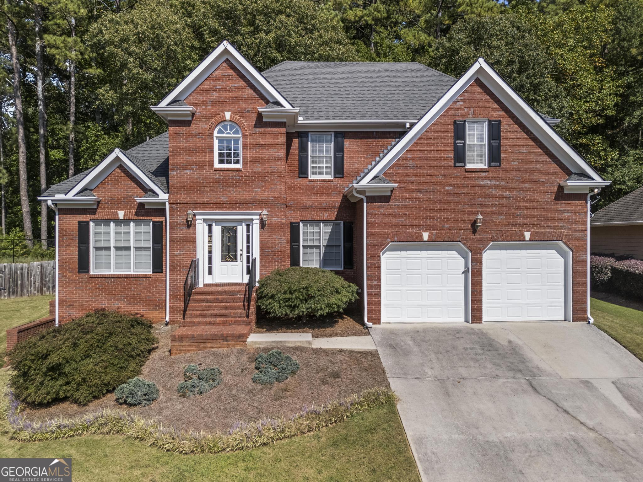 Welcome to a home where entertainment, comfort, and nature converge. Nestled on a cul-de-sac and directly backing up to over 3,000 acres of Kennesaw Mountain National Battlefield Park, this move-in-ready Marietta 5-bedroom/4-bathroom 3-sided brick executive home offers direct private access to scenic trails, abundant wildlife, and a fenced, level backyard with raised garden beds. Outdoor living shines here with an XL screened-in porch and a large deck with built-in seating. The true star of this home is the incredible soundproof theater room-a professionally designed space that rivals a real cinema. Outfitted with tiered leather recliners, dimmable theater lighting, and wall sconces, a full electronics package, a gaming system, a wet bar with a mini-fridge, and even a popcorn machine, it's ready for movie nights and game days. The terrace level also features a private entry with its own patio, spacious family/game room, full bath, generous storage, and a finished bonus room-ideal as a guest space, home gym, or office. A main-level guest suite with a full bath provides the perfect option for in-laws, visiting family, or can be used as a home office. The heart of the home, the light-filled kitchen, was built larger than the original floor plan and includes an oversized walk-in pantry, abundant cabinetry, a center island, and an open flow and view to the great room with access to the roomy screened porch. The main floor features a grand two-story foyer with marble floors, a formal living room, a separate dining room, a great room with a fireplace, and a guest/in-law suite. Upstairs, the luxurious primary suite includes a cozy fireplace, master bath, and huge walk-in closet. A secondary bedroom offers a private sitting area and computer room, and features a Jack-and-Jill bath with an additional bedroom #3. With the flexible spaces throughout, this home is designed for multigenerational living and entertaining. With timeless design and unmatched access to nature, 1703 Rifle Ridge offers a rare lifestyle. Located in the Hillgrove HS award-winning school district and conveniently located to Kennesaw Mountain, hiking trails, historical monuments, KSU, Truist Park, Kennestone Hospital, dining, shopping, major highways, and more.