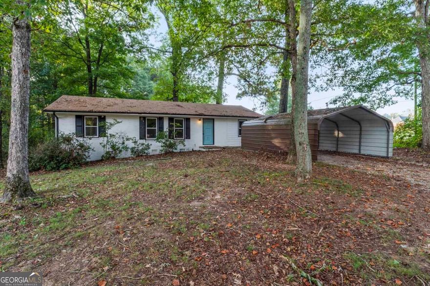 Welcome to 4904 Highway 81 E, located in the sought-after Rock Springs/Ola school district! This charming four-sided home sits on a beautiful 2-acre shaded lot, offering plenty of room to spread out and enjoy the outdoors. Step inside to find original hardwood floors and freshly painted walls and trim, giving the home a warm and inviting feel.  The main hallway leads to two spacious bedrooms and a full tile bathroom. The original carport has been converted into additional finished living space, providing flexible options for a 3rd bedroom, home office, or playroom.   A two-car metal carport has also been added to the driveway for extra covered parking and storage.  This home has already started to receive updates and is ready for your personal touches to make it truly your own. A wonderful opportunity to own a home with character on acreage in a prime McDonough location!