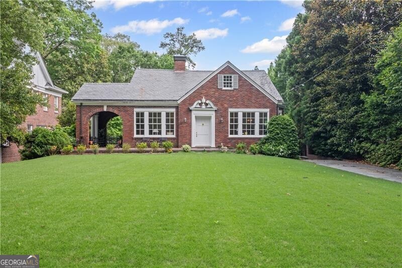 Nestled on one of Morningside's most prestigious and picturesque streets, this classic all-brick Tudor with a distinctive slate roof blends timeless elegance with modern livability. This impeccably maintained 3-bedroom, 2-bath home radiates warmth, character, and natural light throughout. Step inside to find a spacious living room anchored by a beautiful masonry fireplace and rich hardwood floors that flow seamlessly into the formal dining room and throughout the house. The charming vintage kitchen features granite counters and stainless appliances and flows into a cozy breakfast room with butler's pantry - perfect for entertaining and everyday functionality. Original architectural details have been lovingly preserved, while large windows flood each room in sunlight. The home's versatile terrace level-with a separate entrance and an abundance of windows-offers endless possibilities as a home office, second living area, or future guest suite, with plenty of room to add a fourth bedroom and third bath and even a wine cellar. There is a huge attic with permanent stairs that also offers an opportunity for expansion. Enjoy morning coffee or evening conversations on the enchanting side porch with a barrel vault ceiling. The flat, beautifully landscaped lot provides a lush, manicured outdoor space and a private, serene backyard perfect for relaxation or entertaining. A two-car garage completes this rare offering. This is a truly special home in one of Atlanta's most coveted neighborhoods-don't miss the opportunity to make it yours. Conveniently located in Morningside and close to some of the city's best shopping and dining. Nearby you'll find Ansley Mall, Piedmont Park, the Botanical Gardens, Ponce City Market, the Atlanta Beltline, Morningside Elementary and so much more.