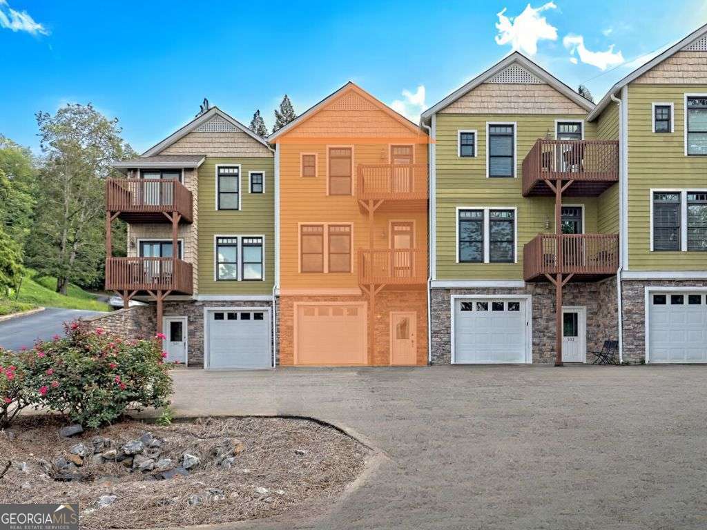 Sunset Bay Condominium on Lake Chatuge offers a practical and efficient living space, including a deeded boat slip, 3 bedrooms, 3 baths, and panoramic views of the lake and mountains. The ground level features a tandem garage with room for two cars and a mechanical and storage area. The ground-level entry and foyer lead upstairs to the open-concept living, kitchen, and dining, complete with a balcony, gas fireplace, high ceilings, and wood floors. The kitchen boasts granite countertops, wood cabinets, stainless steel appliances, a convenient bar for counter dining, and a spacious pantry, plumbed for a washer/dryer, adding a touch of practicality. The main living level is finished with a guest bedroom and bath, while the upper level boasts the Primary Suite, a guest ensuite and a laundry room with a folding counter and cabinets for additional storage. The Primary Suite is a sanctuary of relaxation, featuring a private balcony, amazing views, walk-in closet, spacious bath with a dual granite vanity, and a relaxing whirlpool tub. With its deeded boat slip, this exceptional unit is close to everything Hiawassee and Lake Chatuge offer. The Sunset Bay community offers a lakeside pavilion, grilling area, and fire pit, making it the perfect place to unwind and enjoy a breathtaking view of Lake Chatuge!