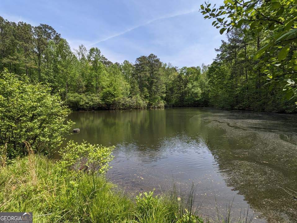 Approximately 54 acres, zoned AG-1, located in prestigious Milton with over 1000ft of road frontage on New Providence Rd.  Hunter's and fisherman's dream.  One of the last parcel of this size in the area. The 54 acres is comprised of two parcels; 22-3550-0997-040-3 and 22-3550-0997-041-1. Income producing: Cell tower month-to-month lease agreement included in sale.   Many possibilities of use... Perfect for 1031 exchange. Buy and hold and let the income from the cell tower pay for taxes and with some, upgrading of the house, additional income can be generated from renting the house.  An additional 17 acres(FMLS#7158177) can be assembled with this property bringing the total acreage to 71 acres.      ATTN: DEVELOPERS/BUILDERS No rezoning needed to build 1 acre minimum lots.  Estate homes in area selling for approximately $2M+.   Best future use is single detached luxury residential redevelopment.  Income producing: Cell tower lease agreement included in sale.      Zoned AG-1, which in Milton mandates that each lot must be at least 1 acre.  Milton development proposals that comply with AG-1 zoning standards are permitted "by-right" and cannot be rejected if they meet all the necessary requirements.  Development incentives are available with some relief to standard subdivision regulations for lots 3 acres and greater.  Income producing: Cell tower lease agreement included in sale.     Terrain: rolling, wooded, creek, pond.  Livable 1968 4BR 3.5BA ranch home on an unfinished basement on property(price does not give value to home). The home on property has great bones and would make a great rental, renovation project or live in it while you build your dream home in area of Million $+ homes. Convenient to Hwy 400, Halcyon, Avalon, Alpharetta City Center and Crabapple Community.  Can also be used for recreation; hunting, fishing, trails throughout    Milton is accessible from Georgia 400, which runs southeast of the City limits, and multiple major highways cross through the city, including Highway 9 / Deerfield Road, State Route 372 / Birmingham Highway, and State Route 140 / Arnold Mill Road.     **APPOINTMENT REQUIRED to walk property. Please do not walk property without making an appointment with Listing agent.**